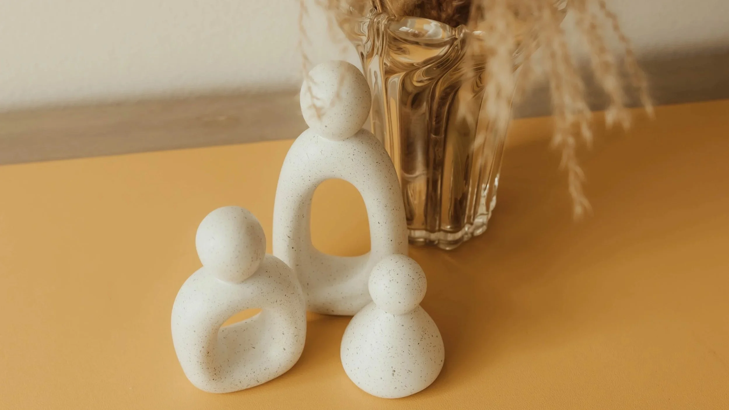 Minimal décor featuring abstract family-inspired figures and natural textures that reflect connection, presence, family wellness, and the calming, holistic atmosphere of Root & Rhythm Holistic Care.