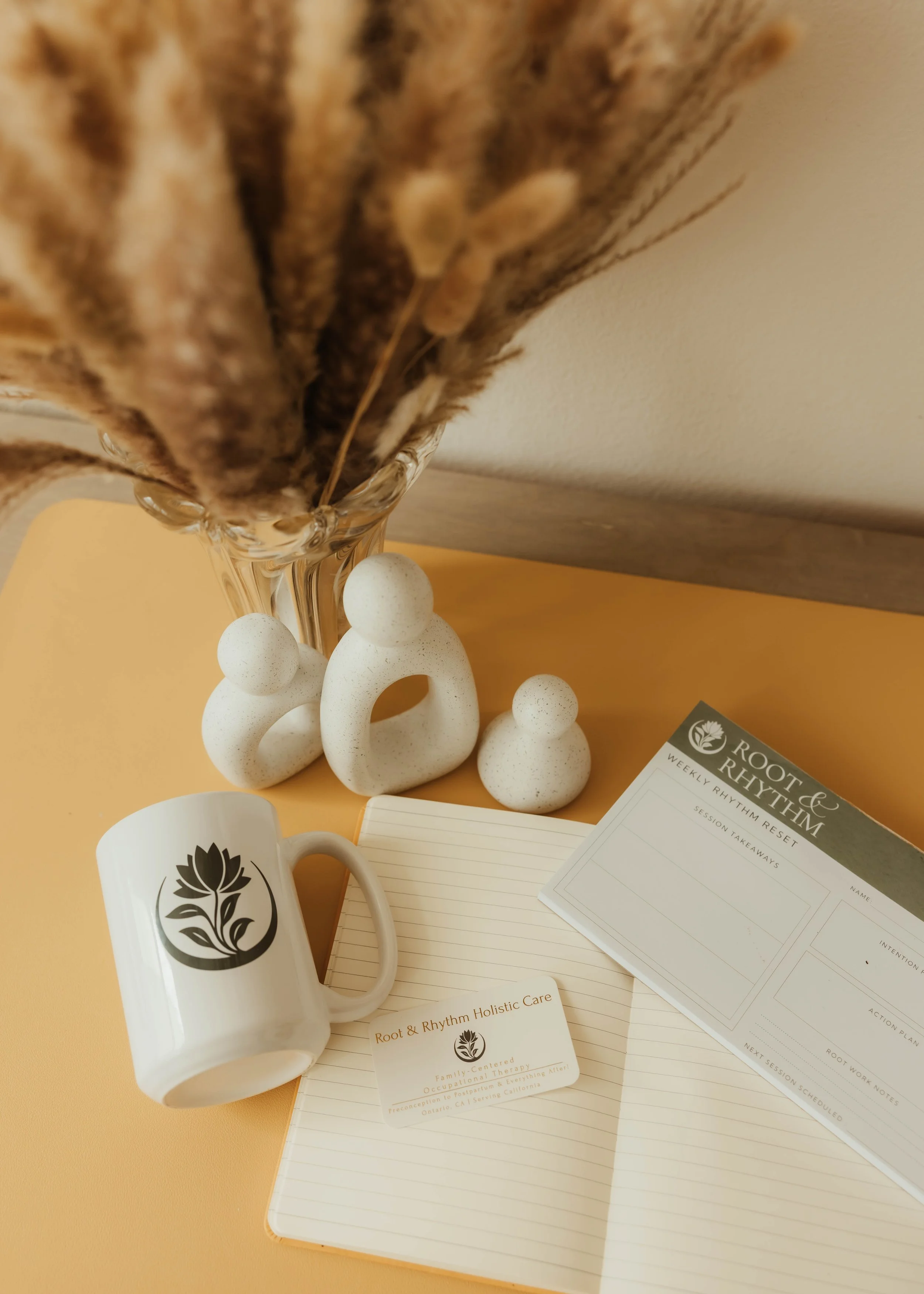 Root & Rhythm Holistic Care materials styled in a warm, grounded setting that reflects holistic wellness, intentional living, and compassionate occupational therapy support for women, mothers, and families.