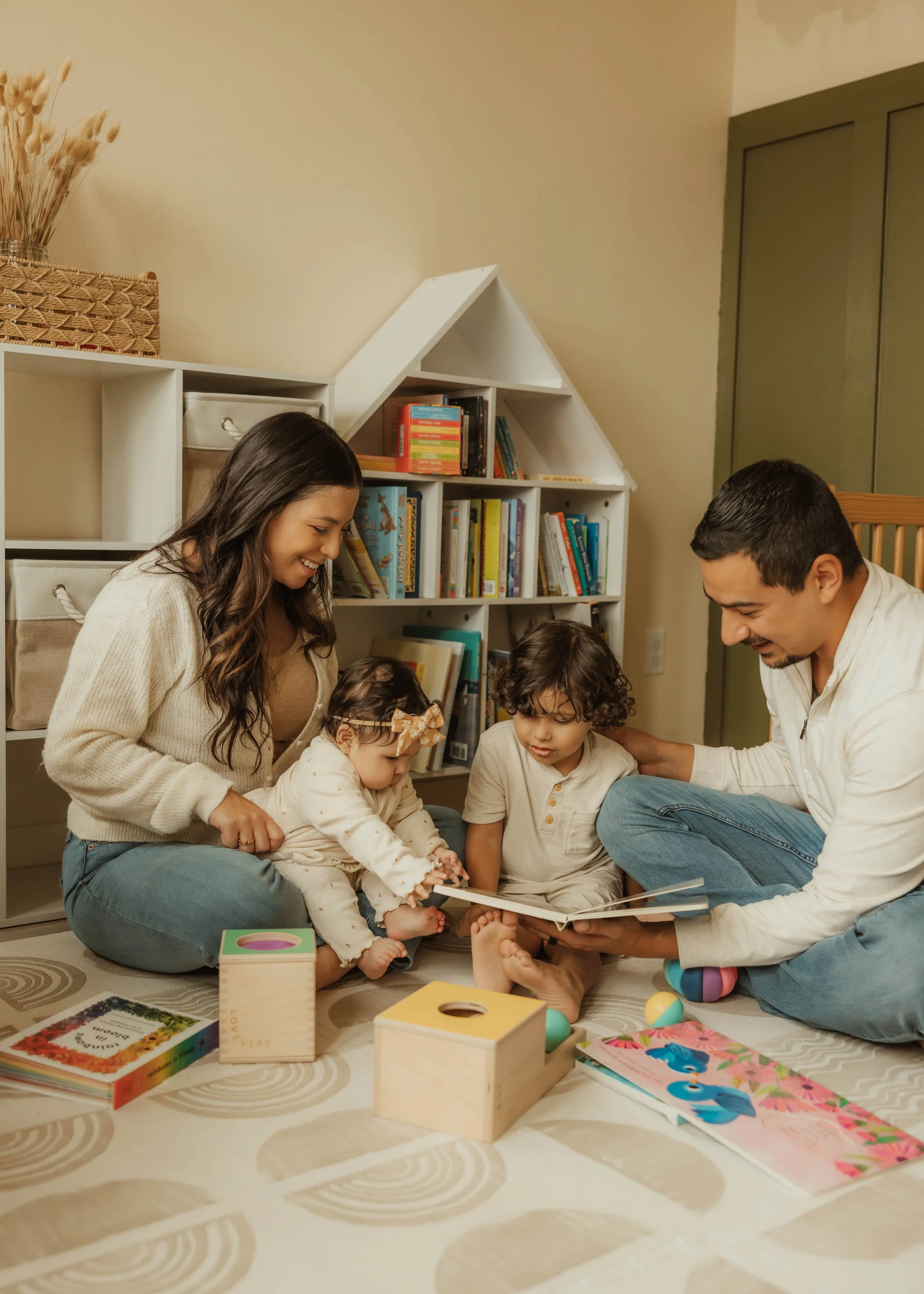 A family reading together in a warm, playful space that reflects connection, co-regulation, learning, and meaningful everyday moments. Occupational therapy at Root & Rhythm Holistic Care supports family routines, relationships, and daily life.