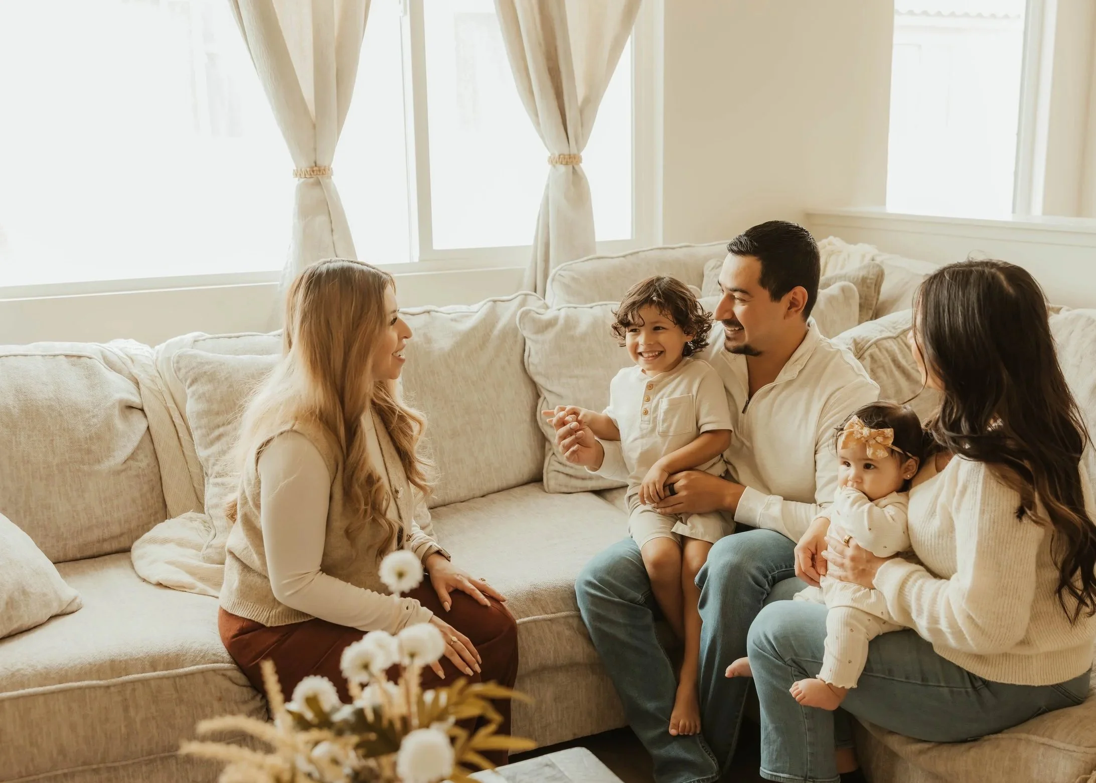 Dr. Salena Gallegos, OTD, OTR/L, founder of Root & Rhythm Holistic Care, connecting with a family in a warm, welcoming space that reflects holistic support, family wellness, motherhood, and meaningful everyday connection.