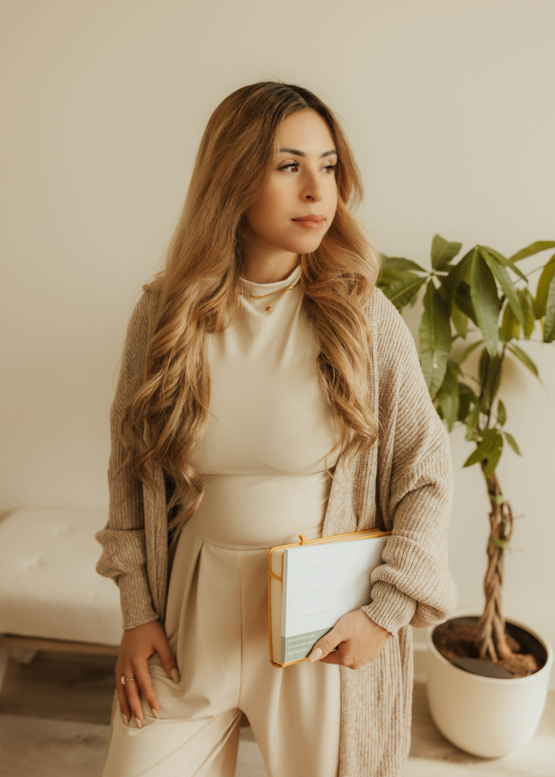 Dr. Salena Gallegos, OTD, OTR/L, holding a planner in a calm, minimal space that reflects intentional living, holistic wellness, and compassionate support through Root & Rhythm Holistic Care.