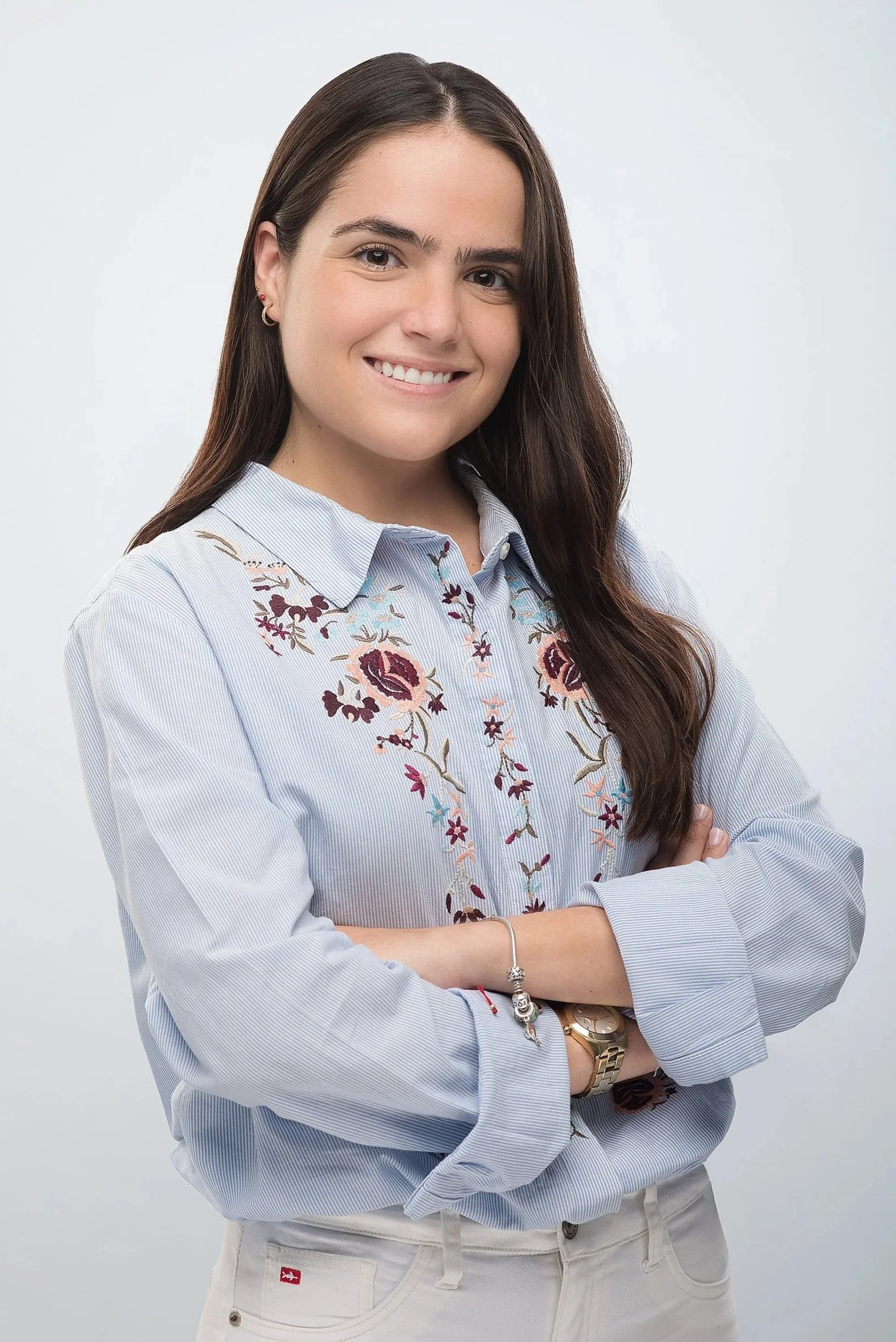 Fotografía en estudio de estilo profesional, con pose ligeramente creativa, como brazos cruzados o sonrisa sutil.