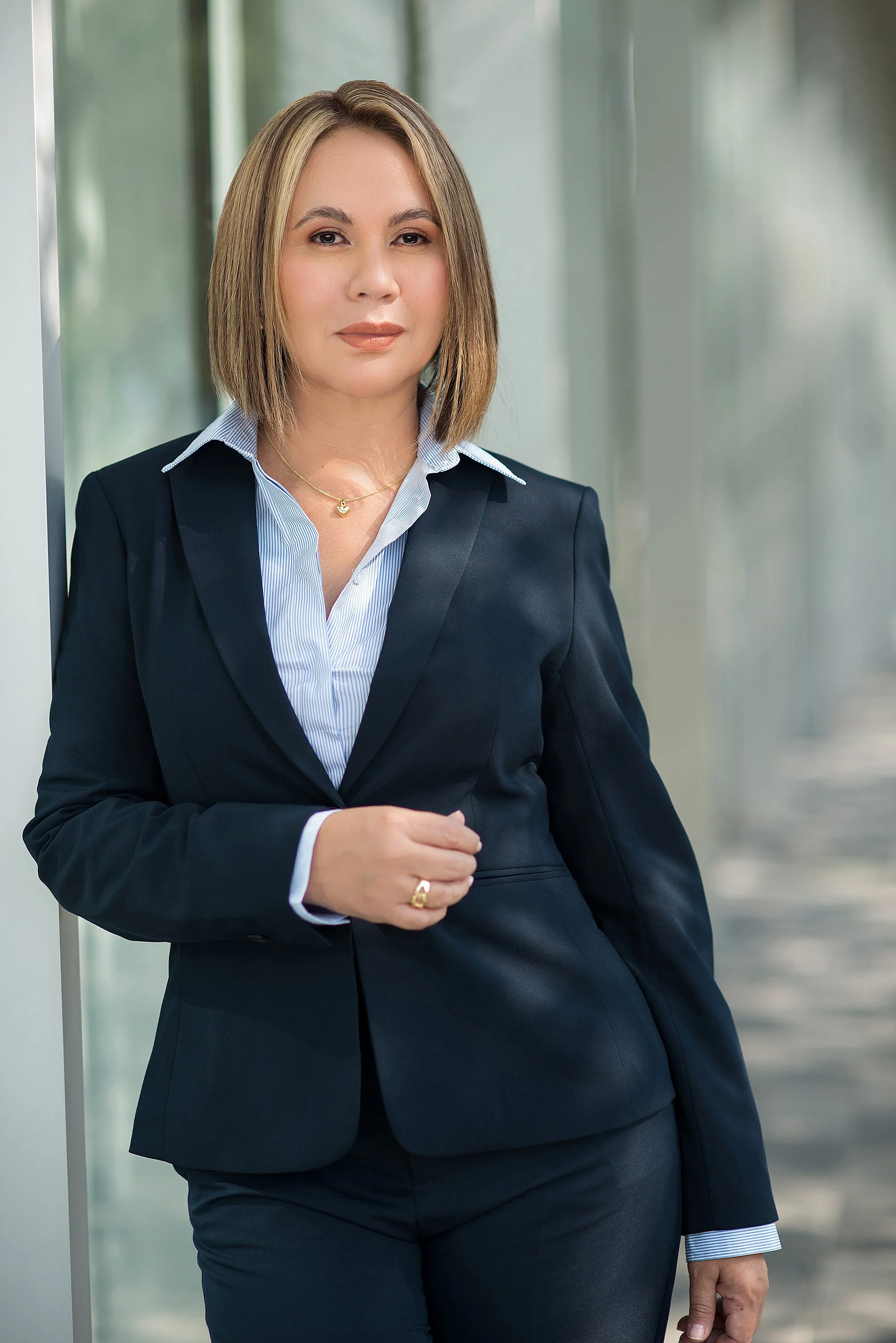 Retrato en estudio de una abogada con expresión firme y elegante. Fondo neutro y luz cuidada para reflejar autoridad, claridad y confianza. Ideal para quienes trabajan en el sector legal, institucional o corporativo.