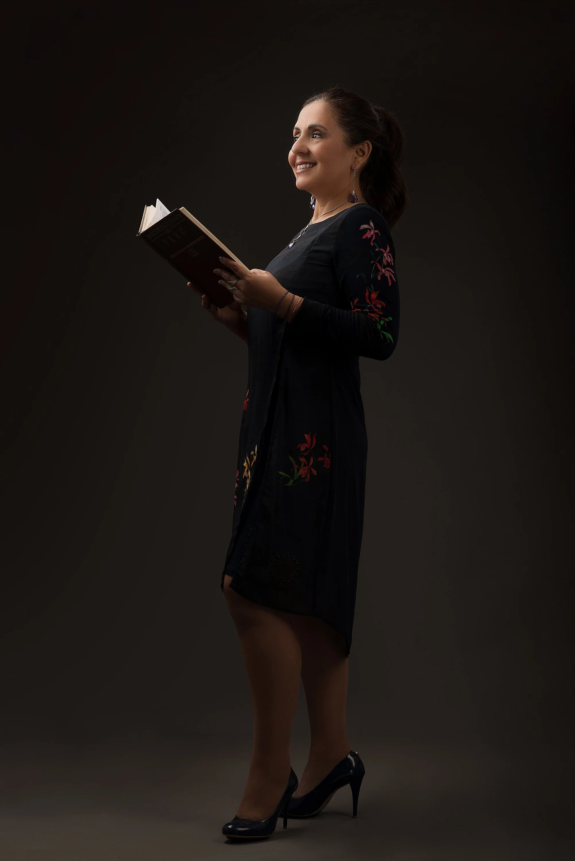 Fotografía en estudio de una escritora en pose relajada, con su libro en manos y expresión introspectiva. Imagen que transmite sensibilidad, profundidad y conexión con su obra. Perfecta para portadas de autoras, entrevistas o eventos literarios.