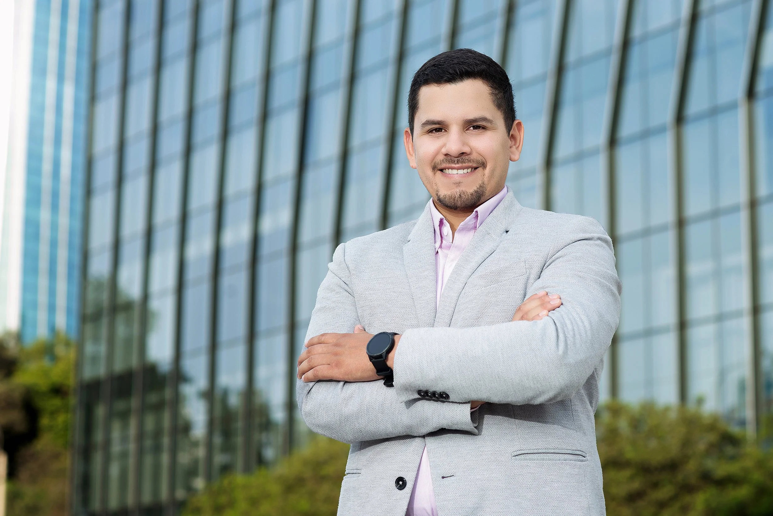 Foto de perfil profesional en exteriores para LinkedIn con fondo urbano desenfocado.