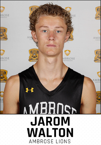 Young male basketball player in a black jersey with 'AMBROSE' and 'JAROM WALTON' printed on it, standing in front of a backdrop with the Ambrose Lions logo.
