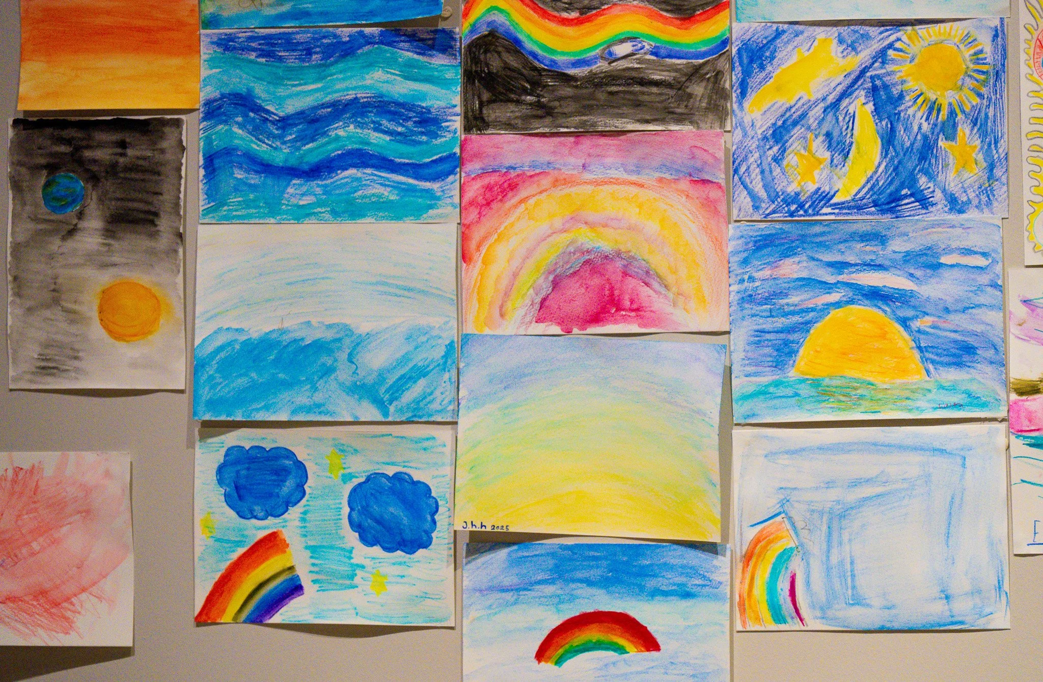 Watercolor paintings hanging on a wall done by a group of students