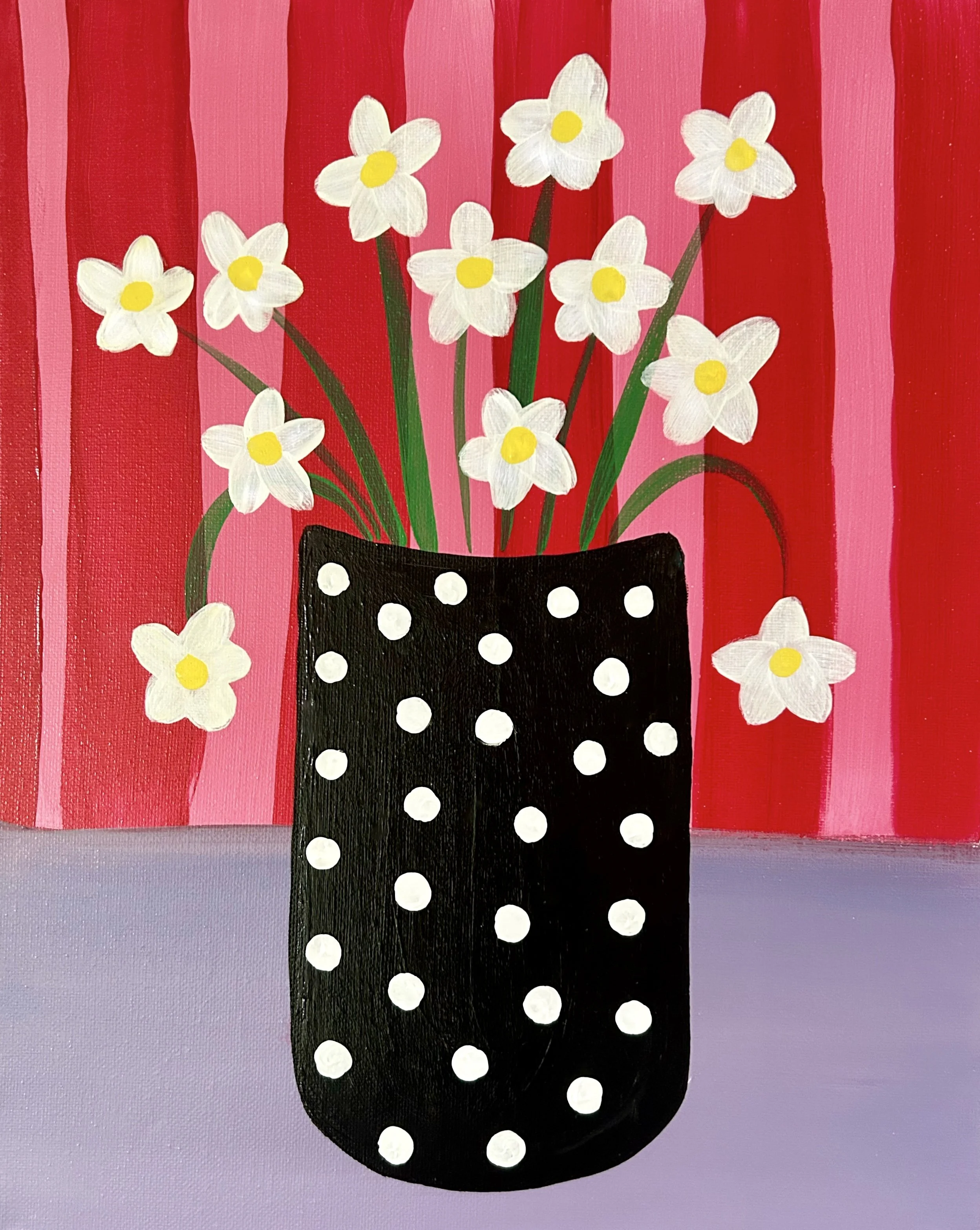 Up close photo of a painting of white daisy flowers in a black polka dot vase on a purple table with red and pink stripes in the background