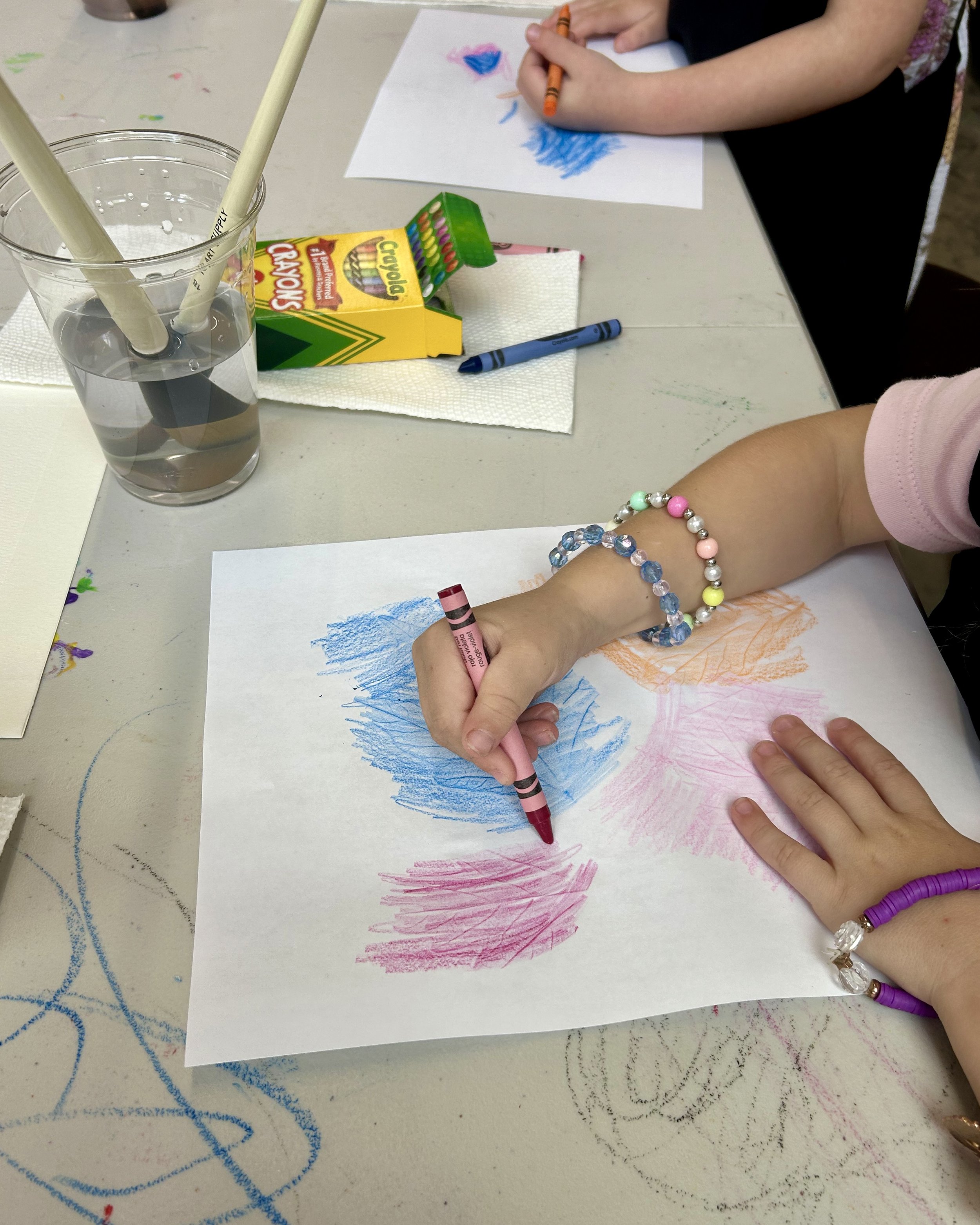 Close up of students coloring leaf rubbings