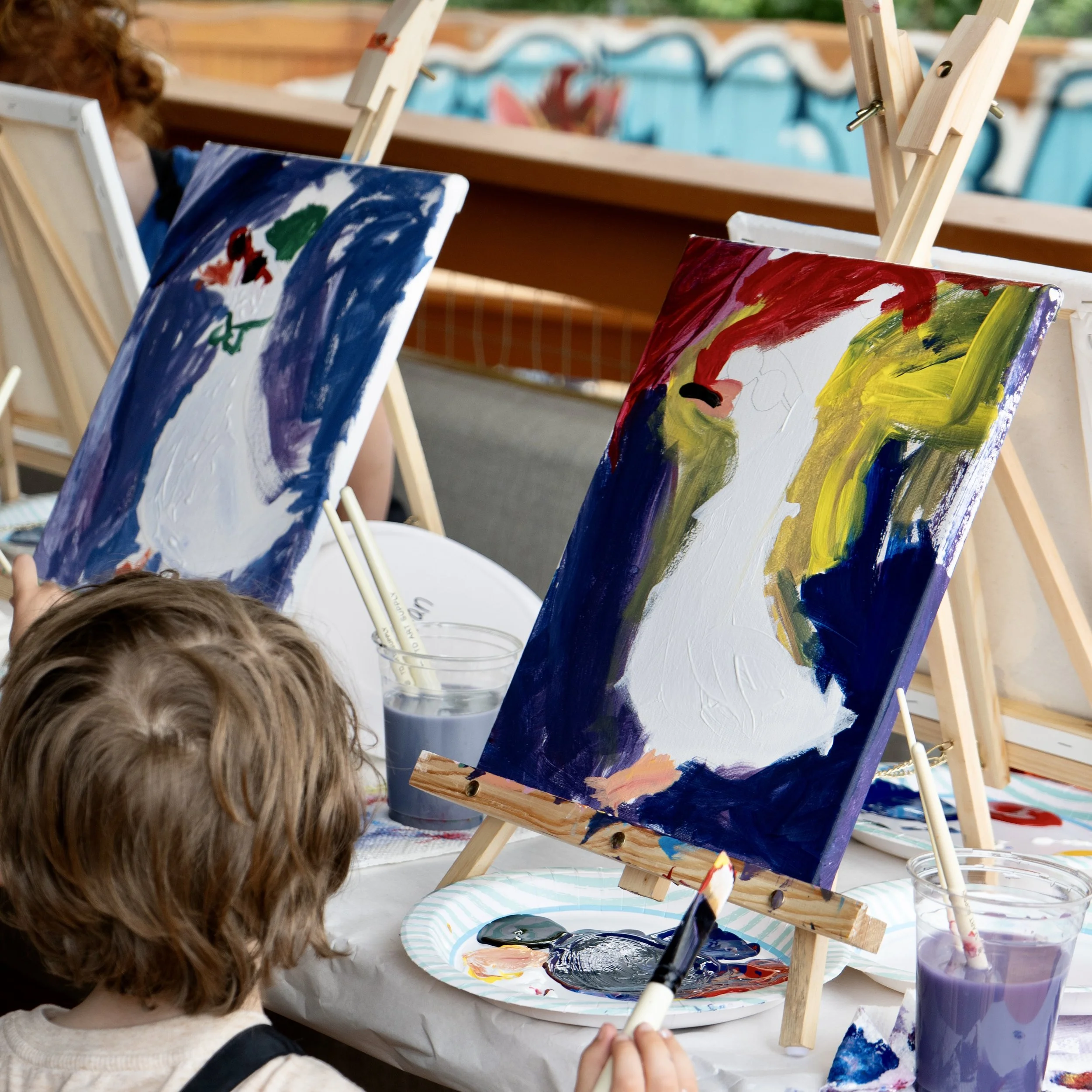 Two paintings of geese with bright colors done at a kids class