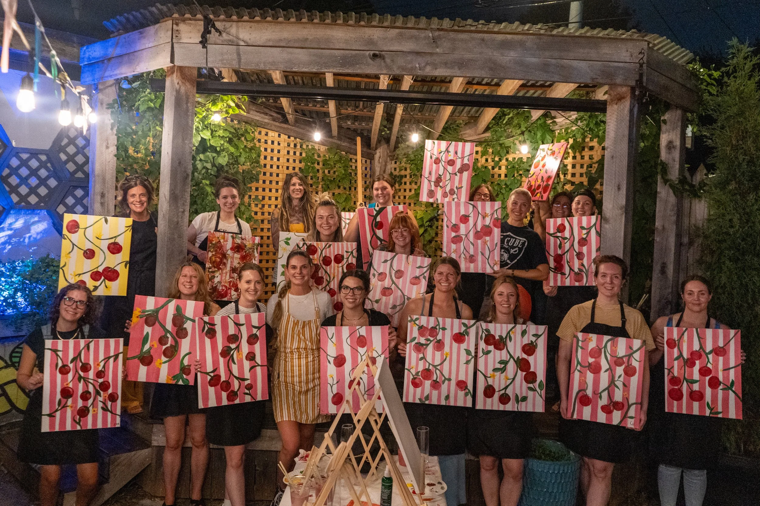 Group of women holding tomato paintings on stage