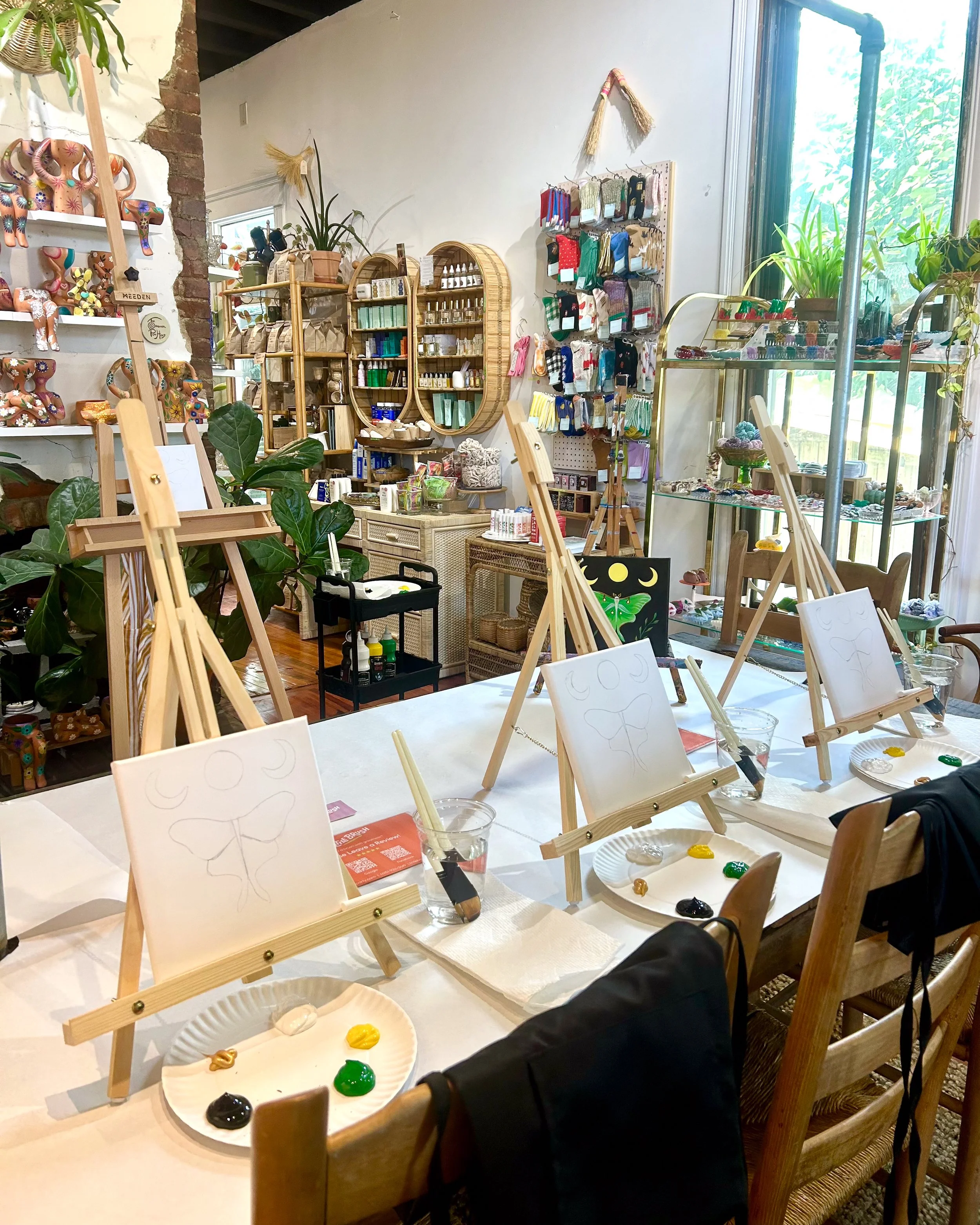 Small square canvases on easels in an eclectic shop