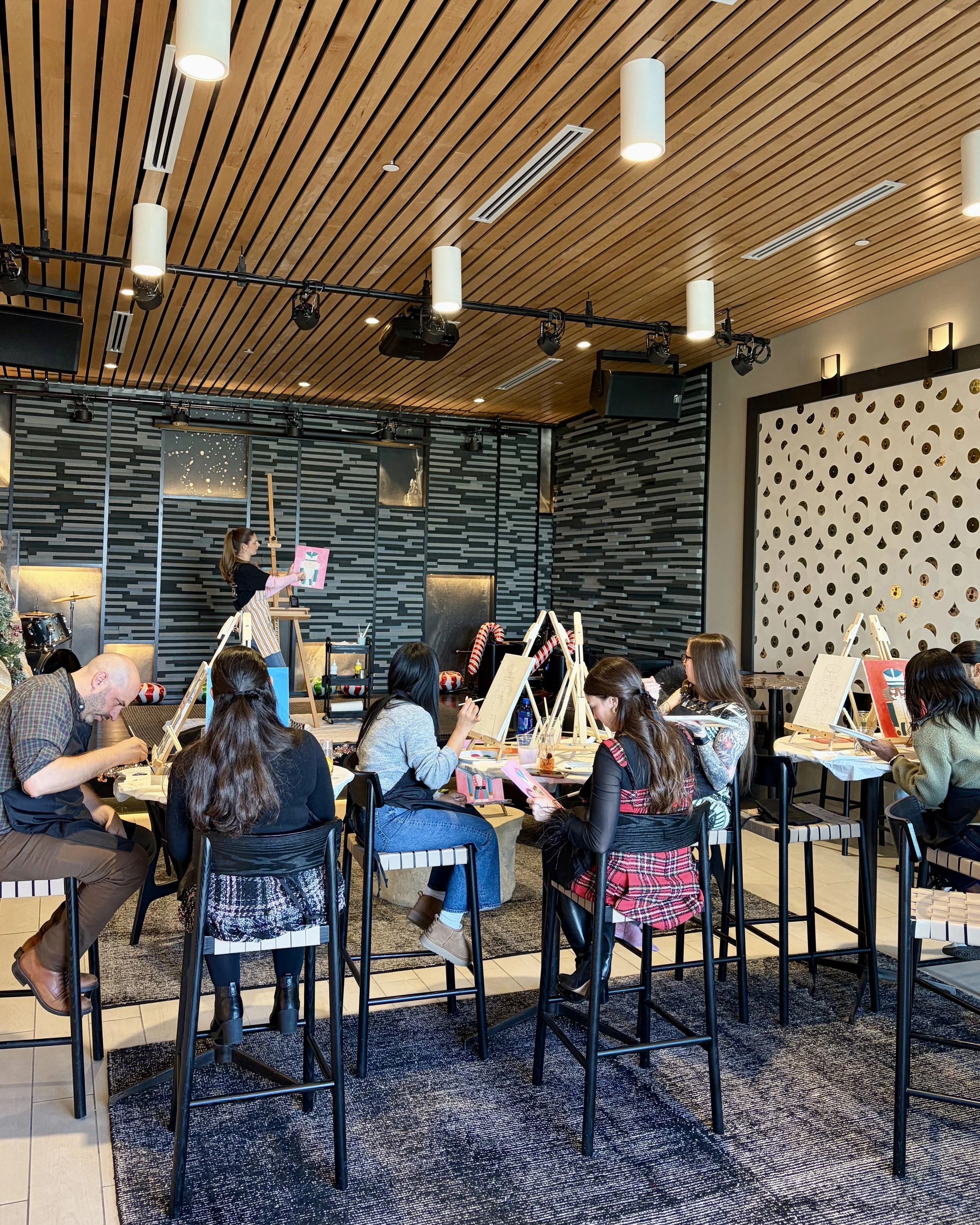 Group of adults painting nutcracker paintings in an event space