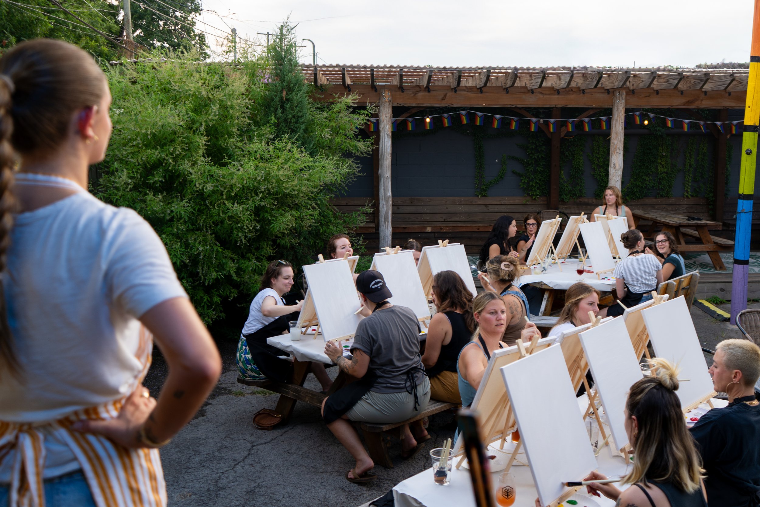 An instructor gazes out at the crowd of students painting outside in a courtyard