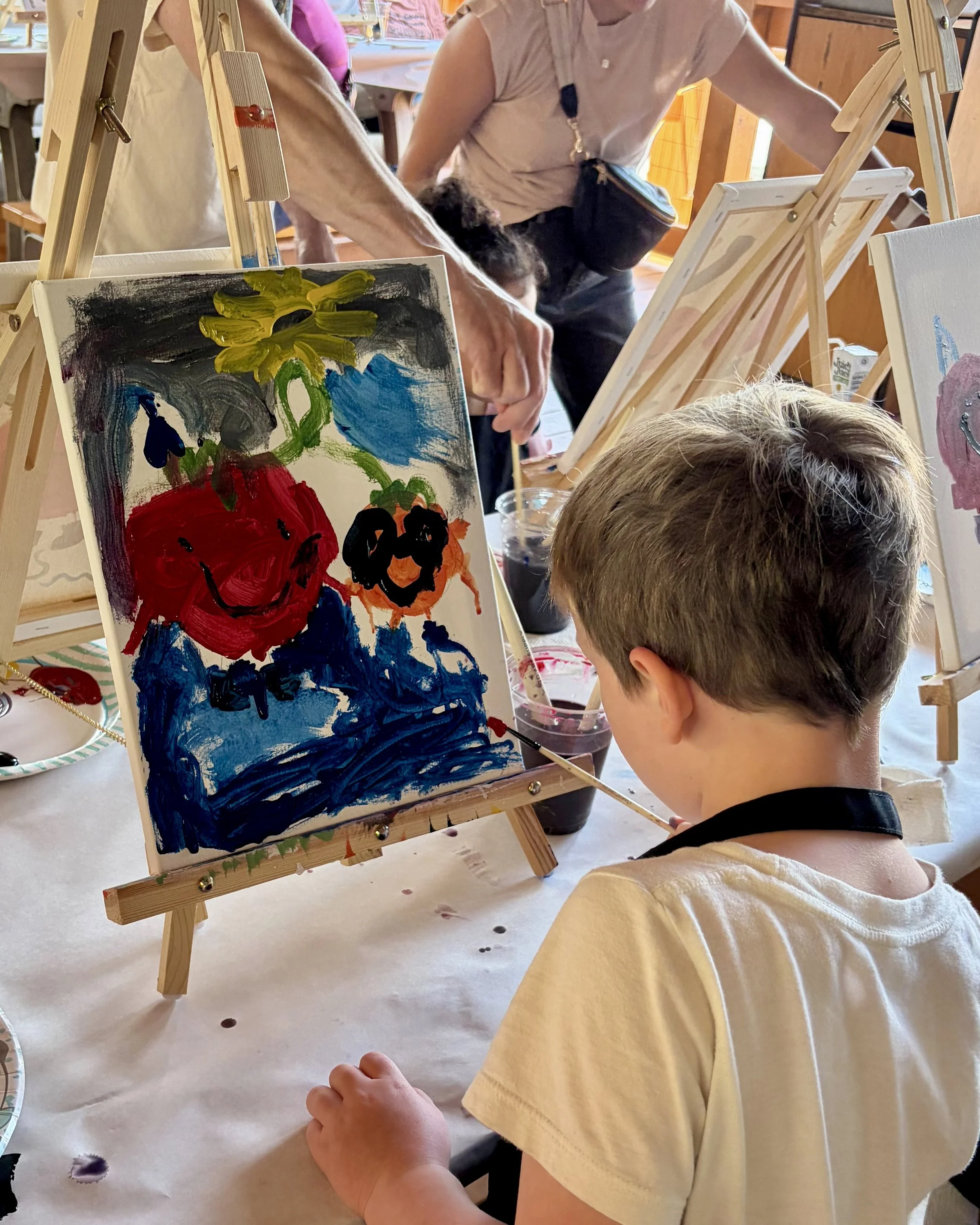 Little boy painting a colorful tomato design