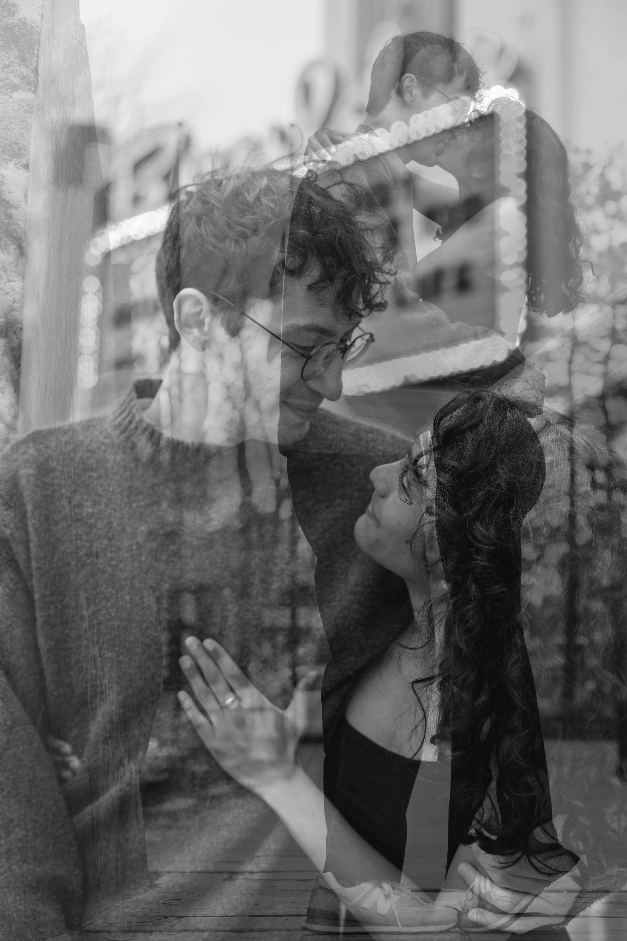 A double exposure photo.  The couple is making eye contact with each other, her engagement ring and hand on his chest.  The second exposure is them kissing under a vintage theater sign, where they had their first date.