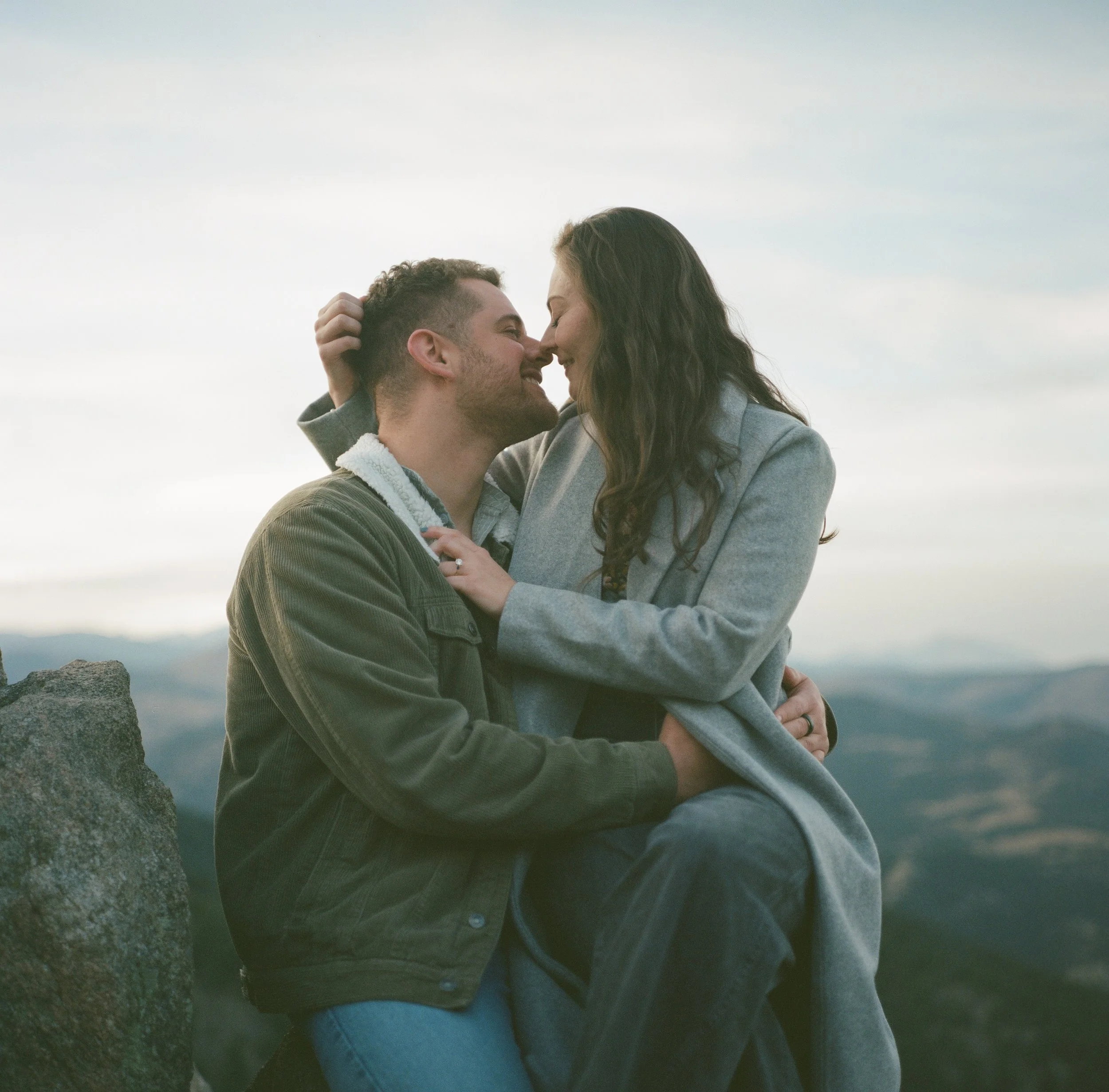 A couple about to kiss in a candid and authentic moment.  The photo is on medium format film, giving a warm classic tone.