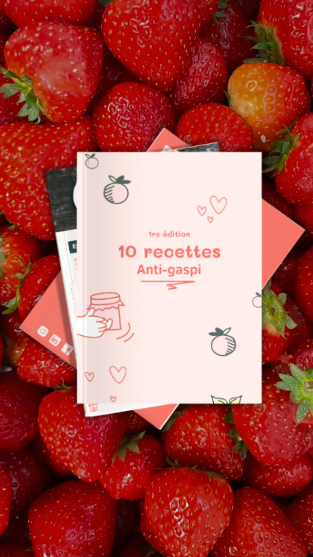 Livre de recettes anti-gaspi posé sur des fraises rouges