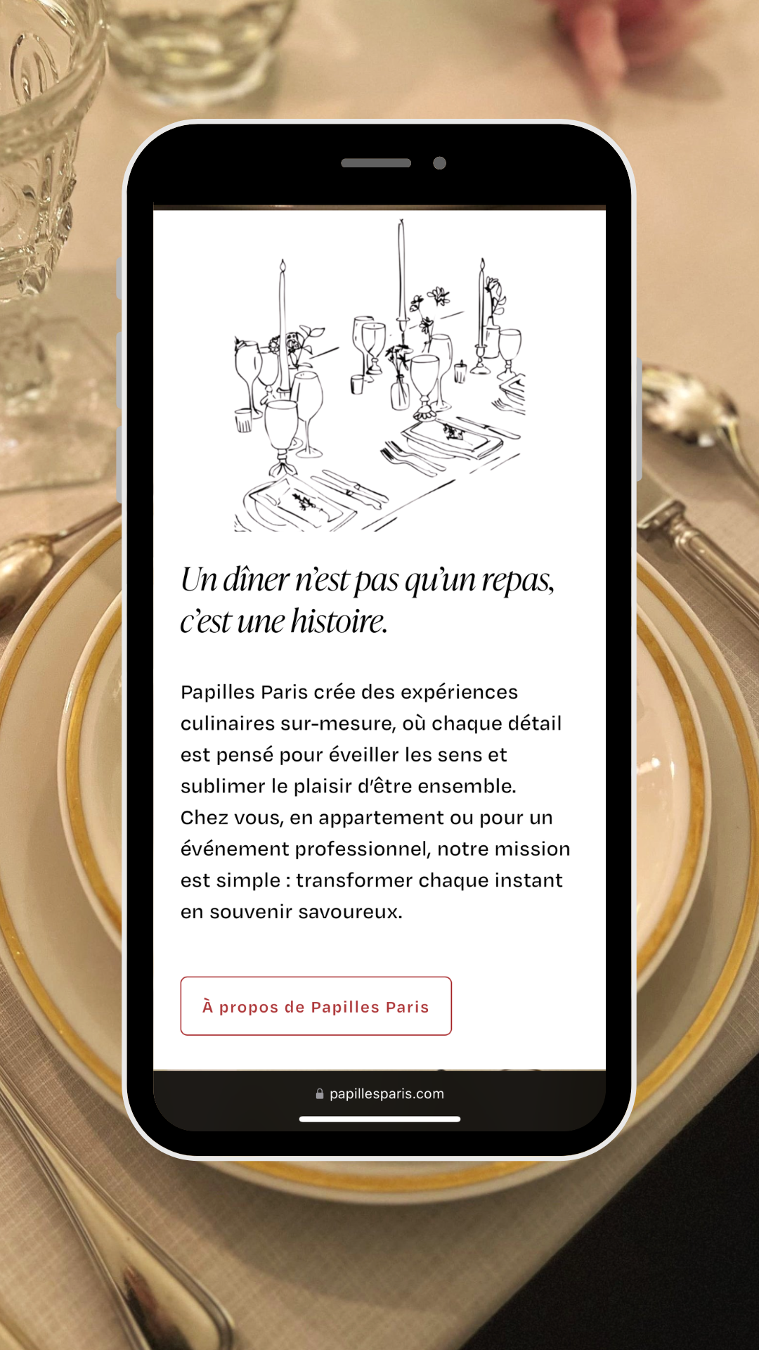 Écran de téléphone affichant une page web avec une illustration d'une table dressée et un texte en français.