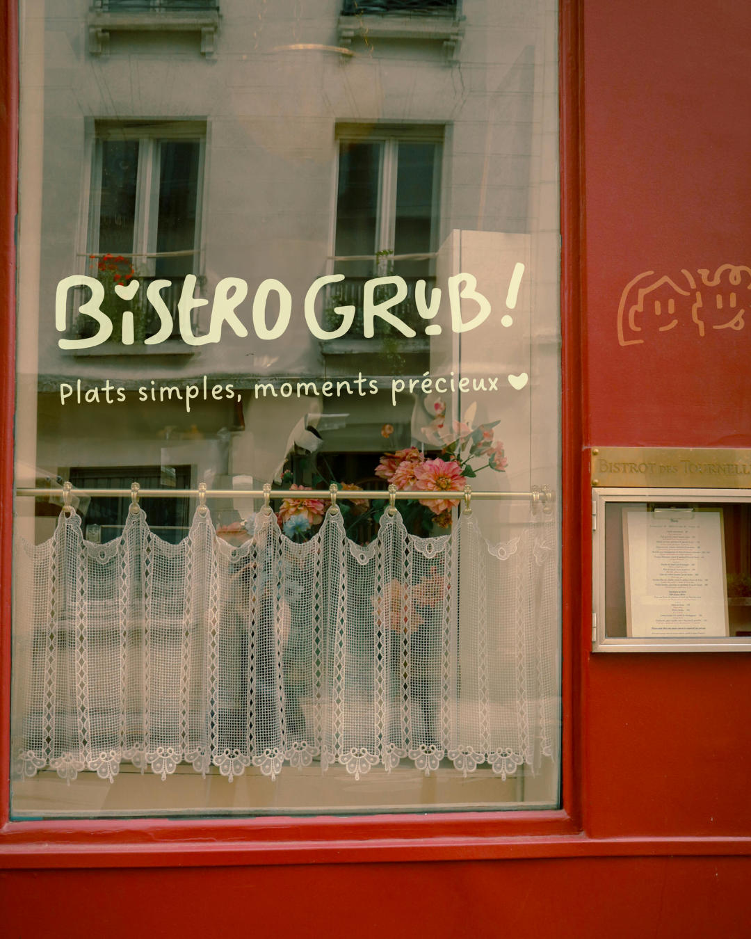 Fenêtre d'un bistrot avec des fleurs et un rideau en dentelle, inscription en français 'Bistro GRUB! Plats simples, moments précieux'.