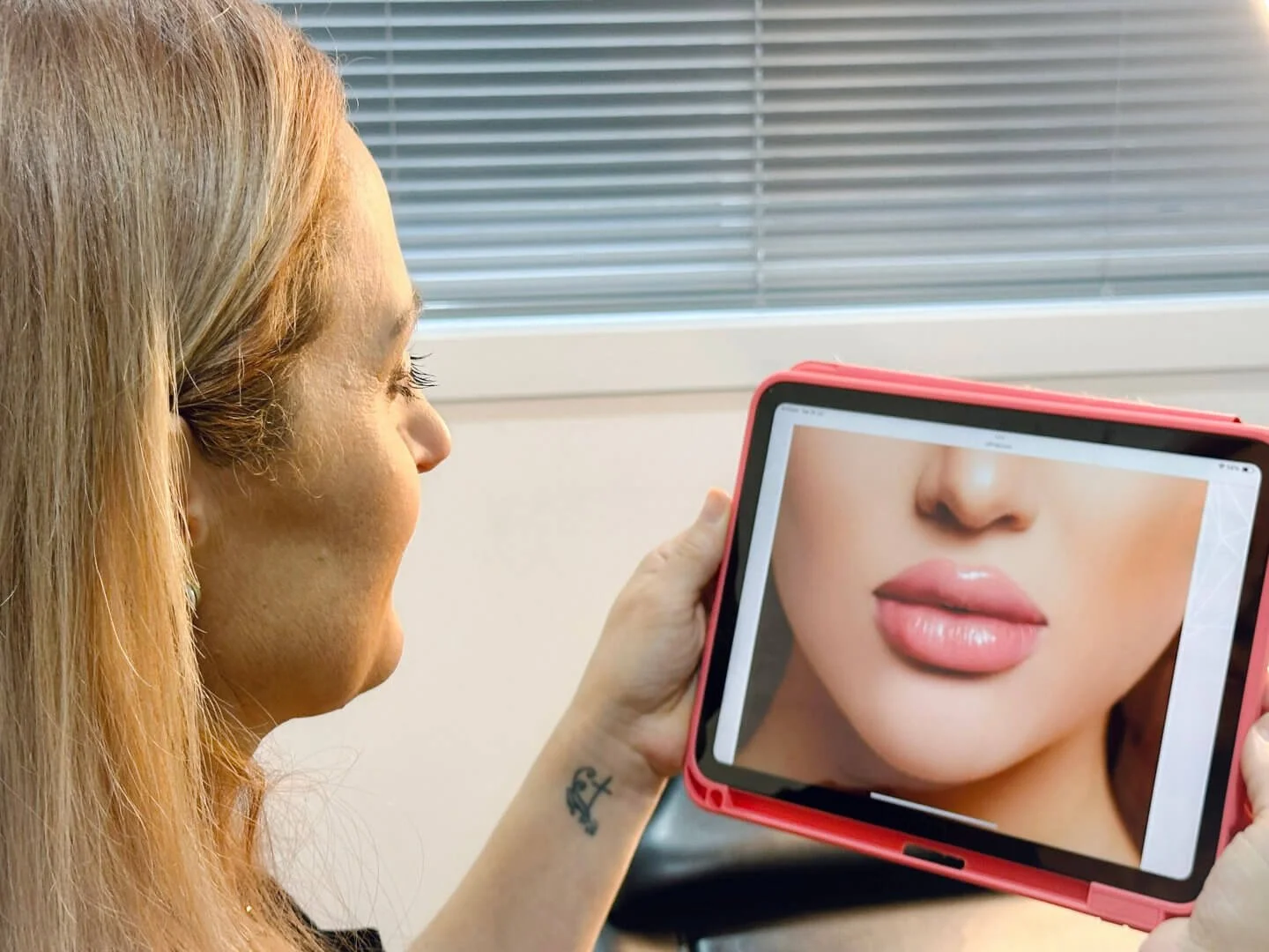 RN Jolieta is looking at a large tablet with a close-up image of a woman's lips on the screen.