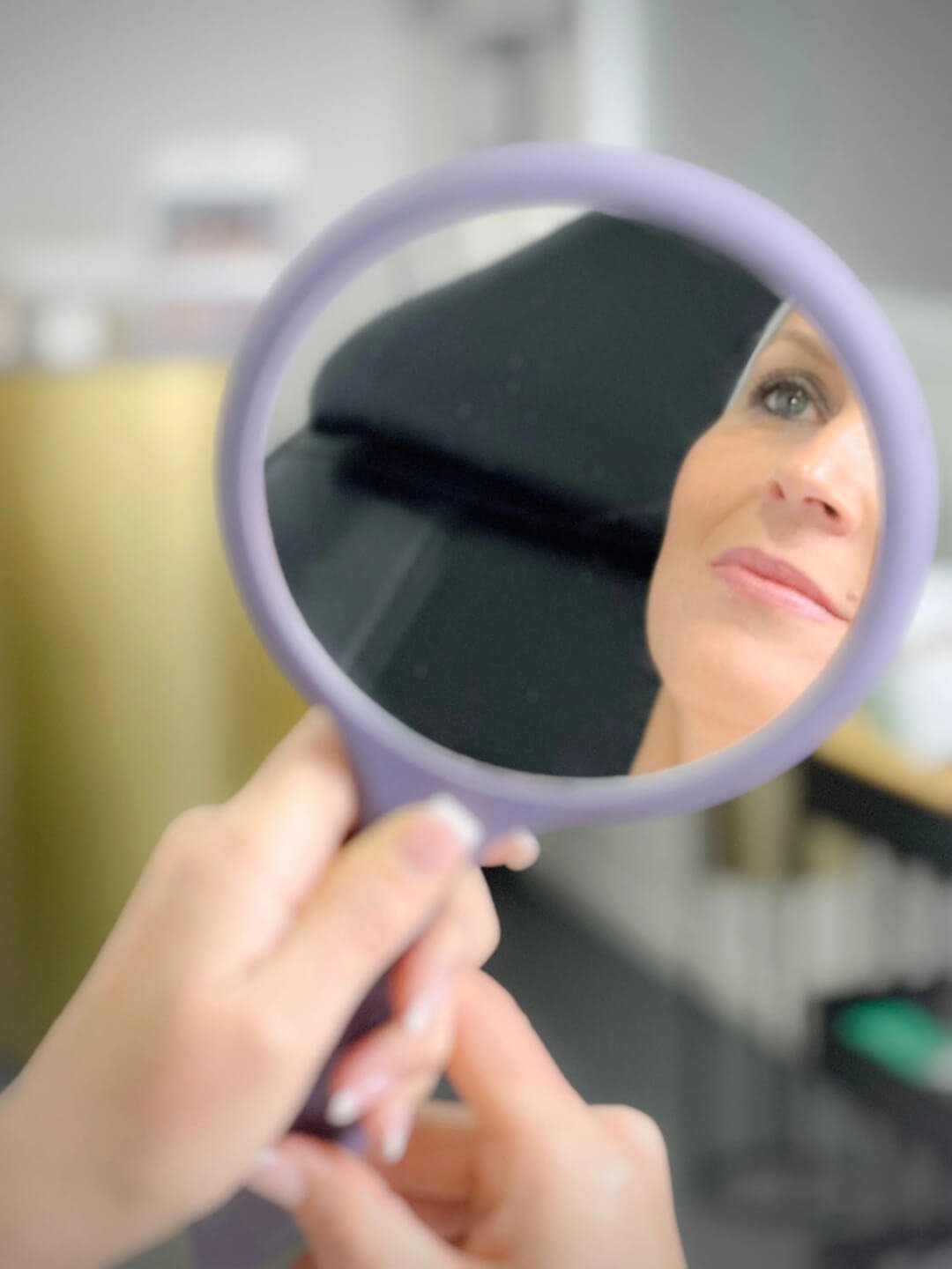 Client looking in a mirror before an aesthetic treatment.
