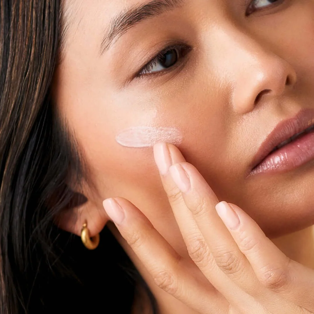 Client applying Daily Defence SPF50 to her face.