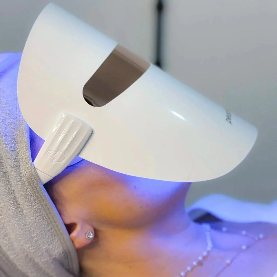 Client relaxing under an LED light therapy mask following a PRX Plus brightening treatment at Beauty WithIn Aesthetics.