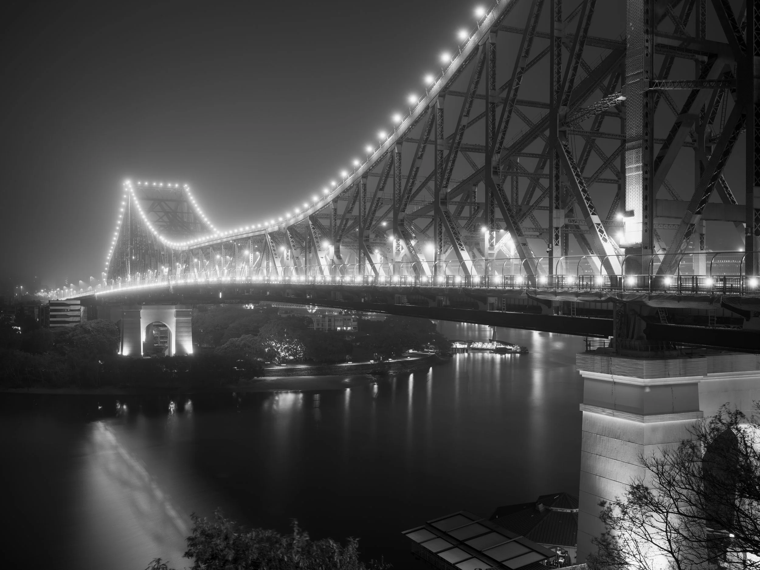 Black and white photo of Brisbane Story Bridge at night in fog