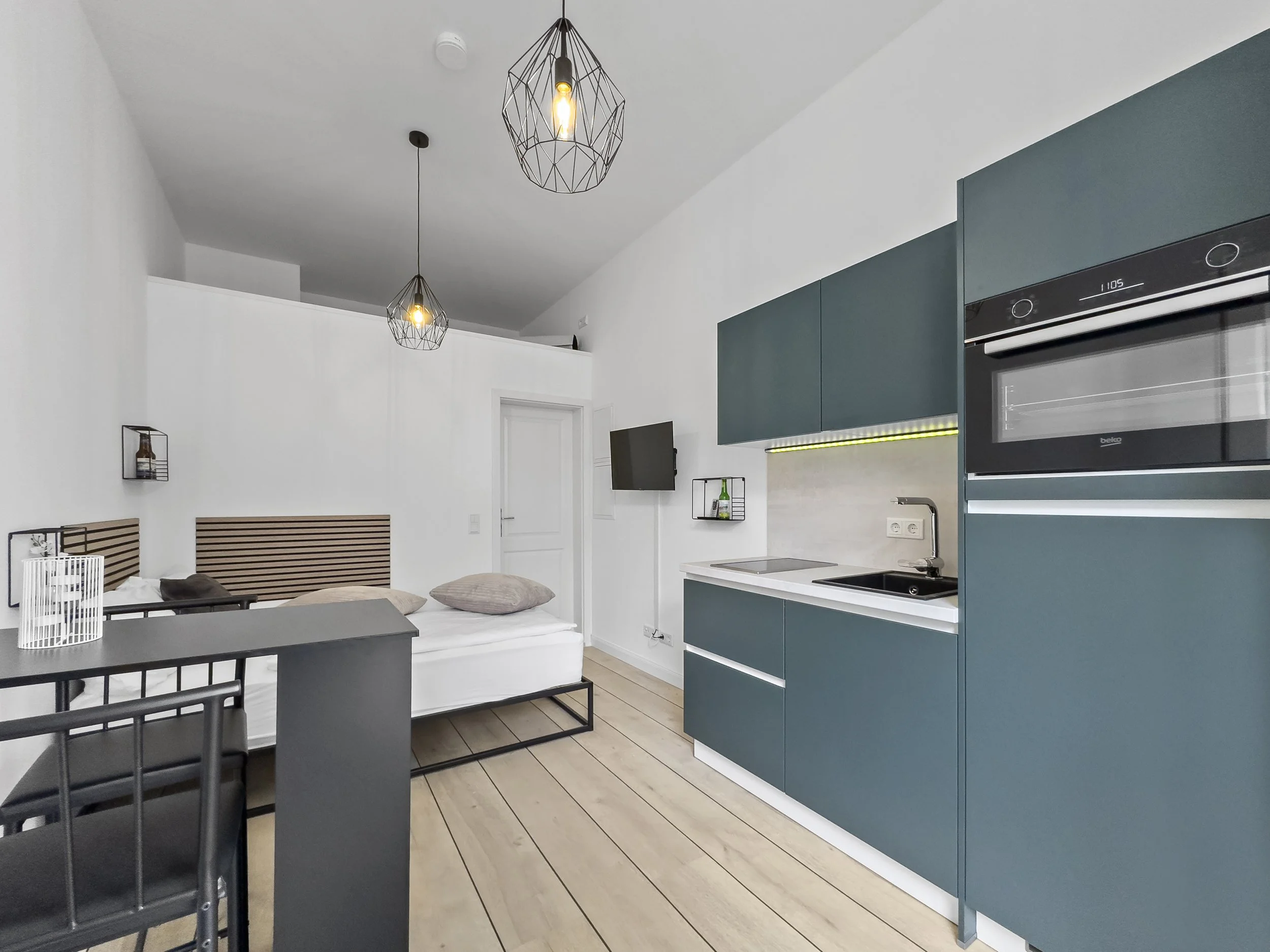 Restaurierte helle und freundliche Einzimmerwohnung mit moderner Einbauküche, Bett, Tresen und TV