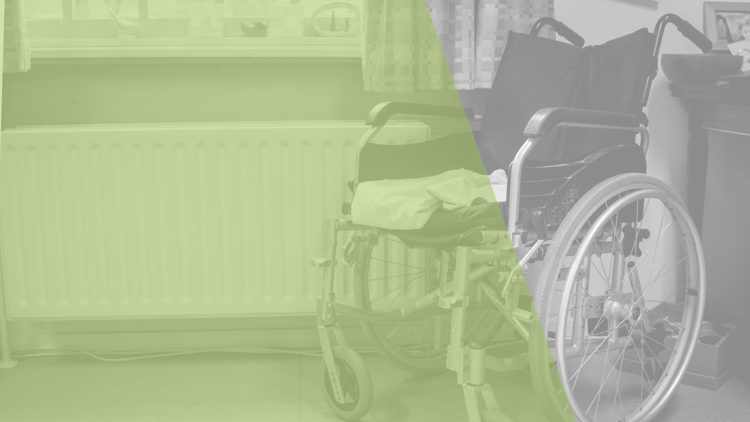 A black wheelchair with a seat cushion and some clothing on it, positioned near a window with curtains, a radiator, and a small side table with photographs and items in the background.
