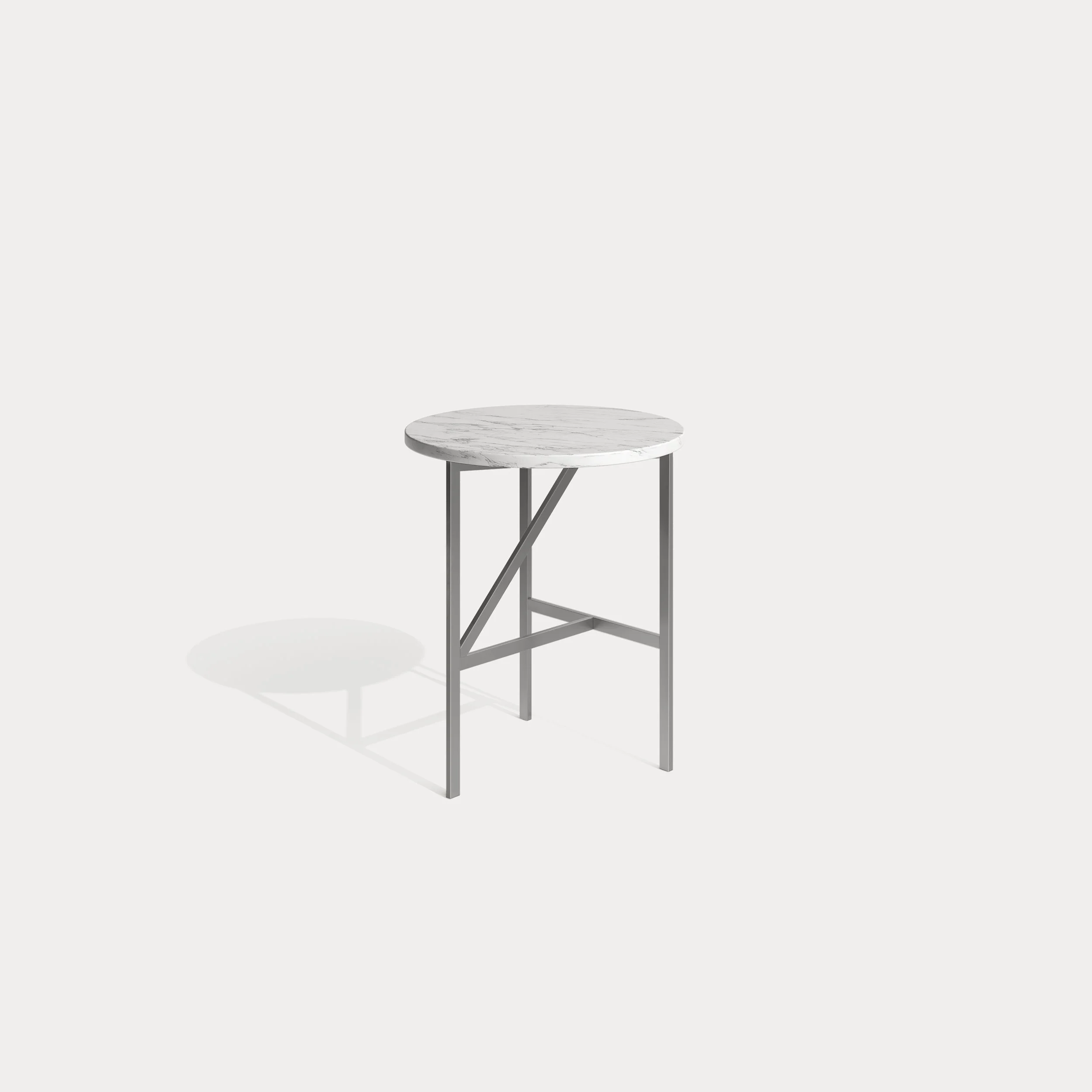 A modern round table with a white marble top and metal frame, casting a shadow on a plain light gray background.