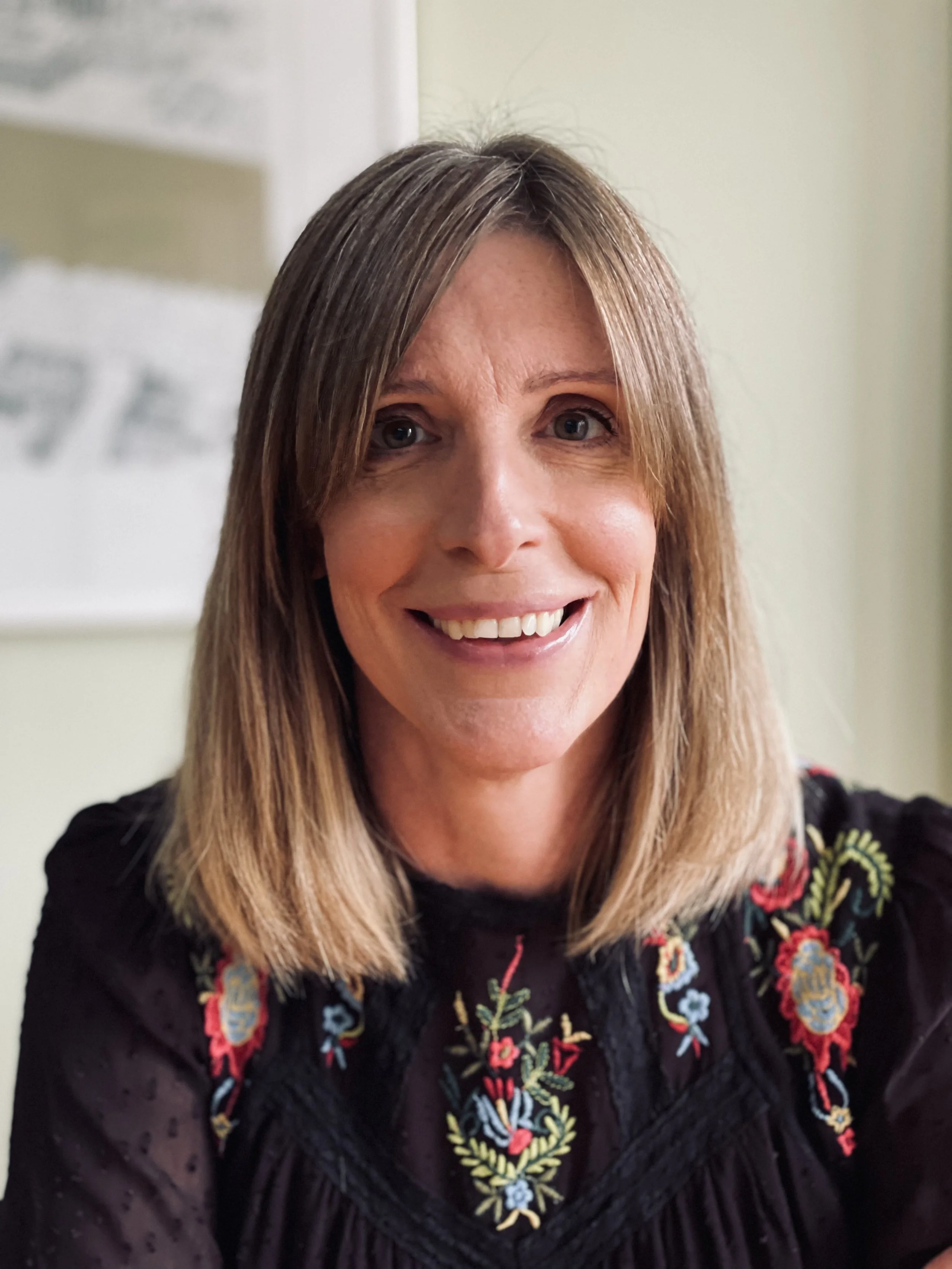 Sasha Neal smiles at the camera with shoulder-length blonde hair.