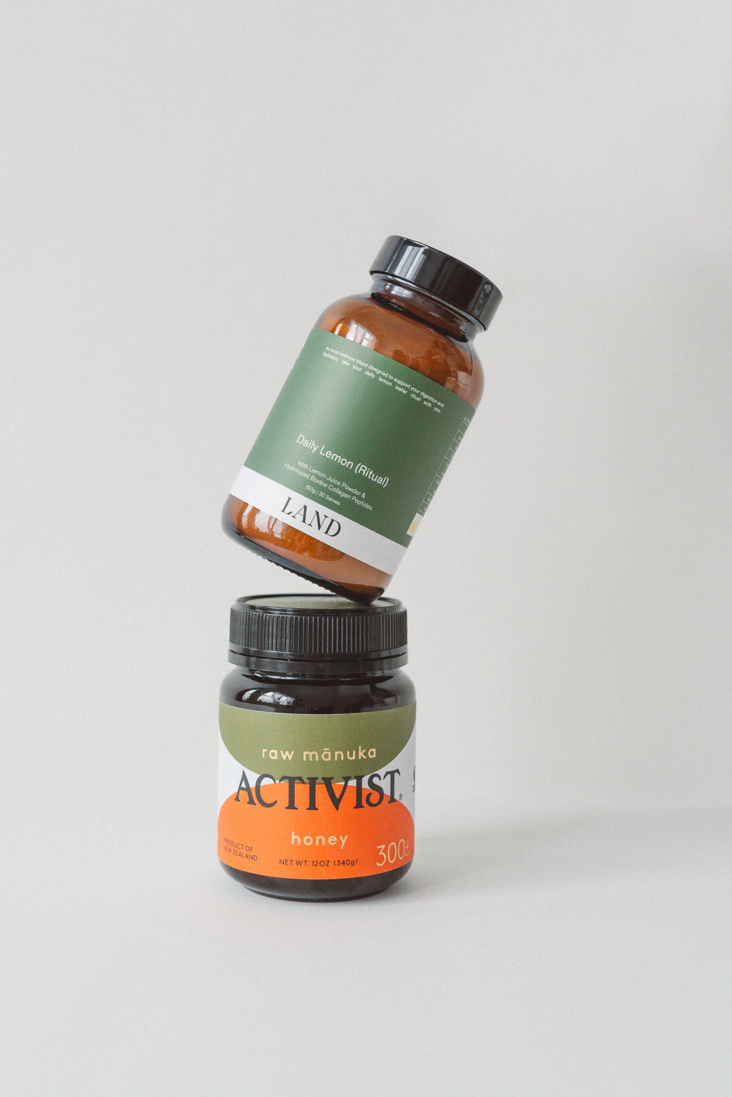 Three bottles stacked vertically against a white background. The top bottle is an amber plastic bottle labeled 'Daily Lemon (Ritual)' containing lemon juice powder and collagen peptides. The middle bottle is a dark capsule bottle, and the bottom bott