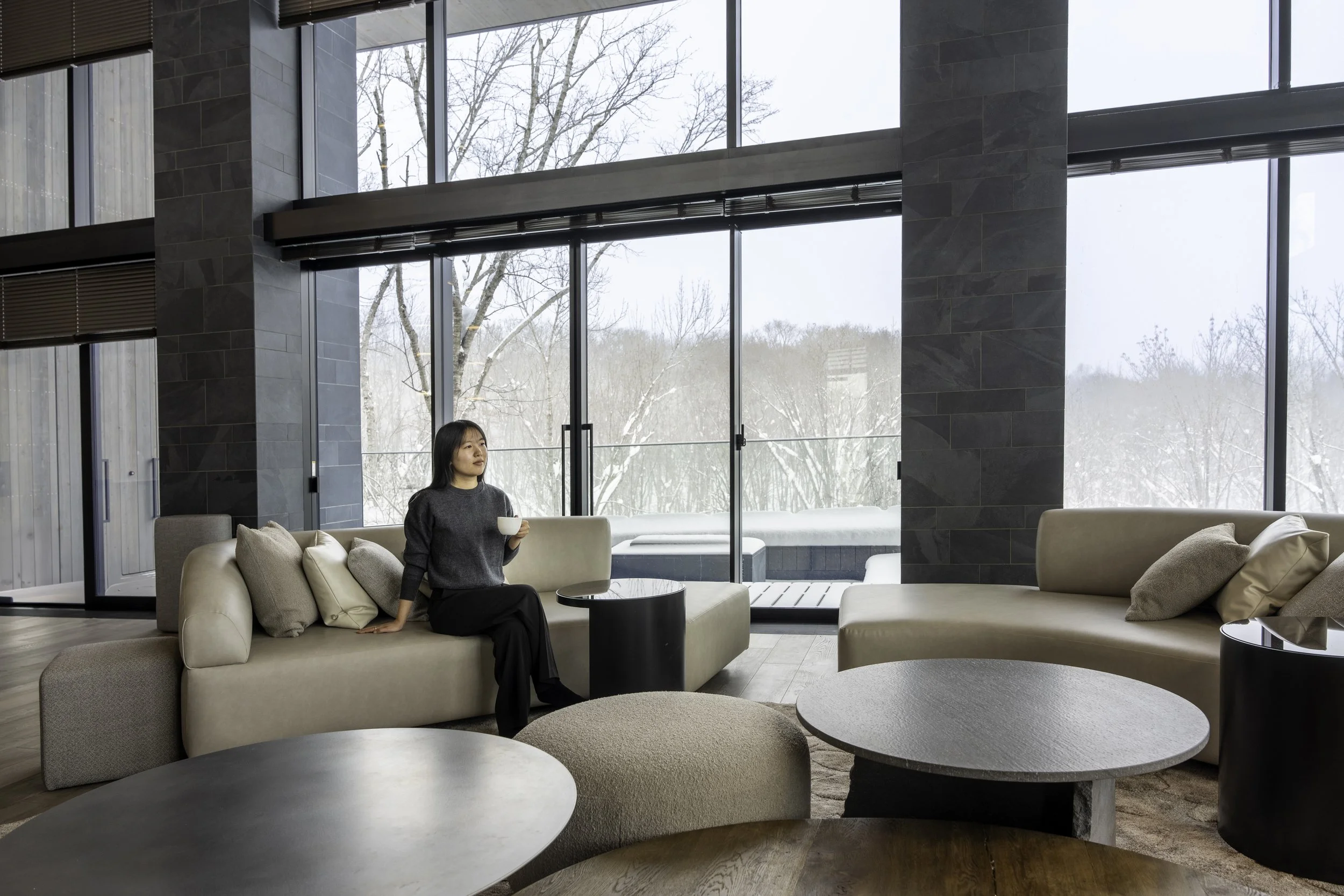 Corniche Hirafu Luxury Chalet in Niseko, Woman Drinking Coffee in Open-plan Living Room
