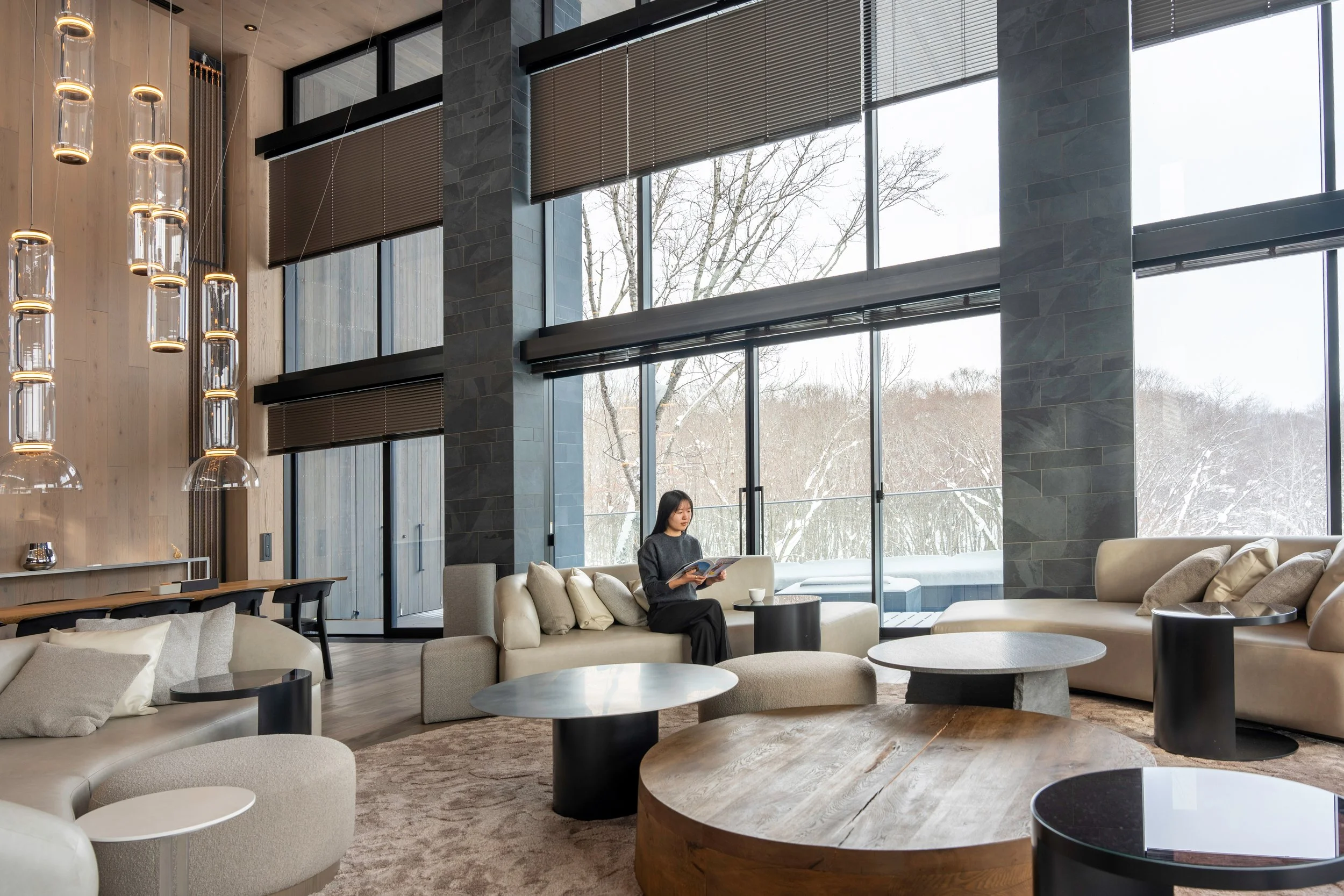 Corniche Hirafu Luxury Chalet in Niseko, Woman Reading Magazine in Living Area