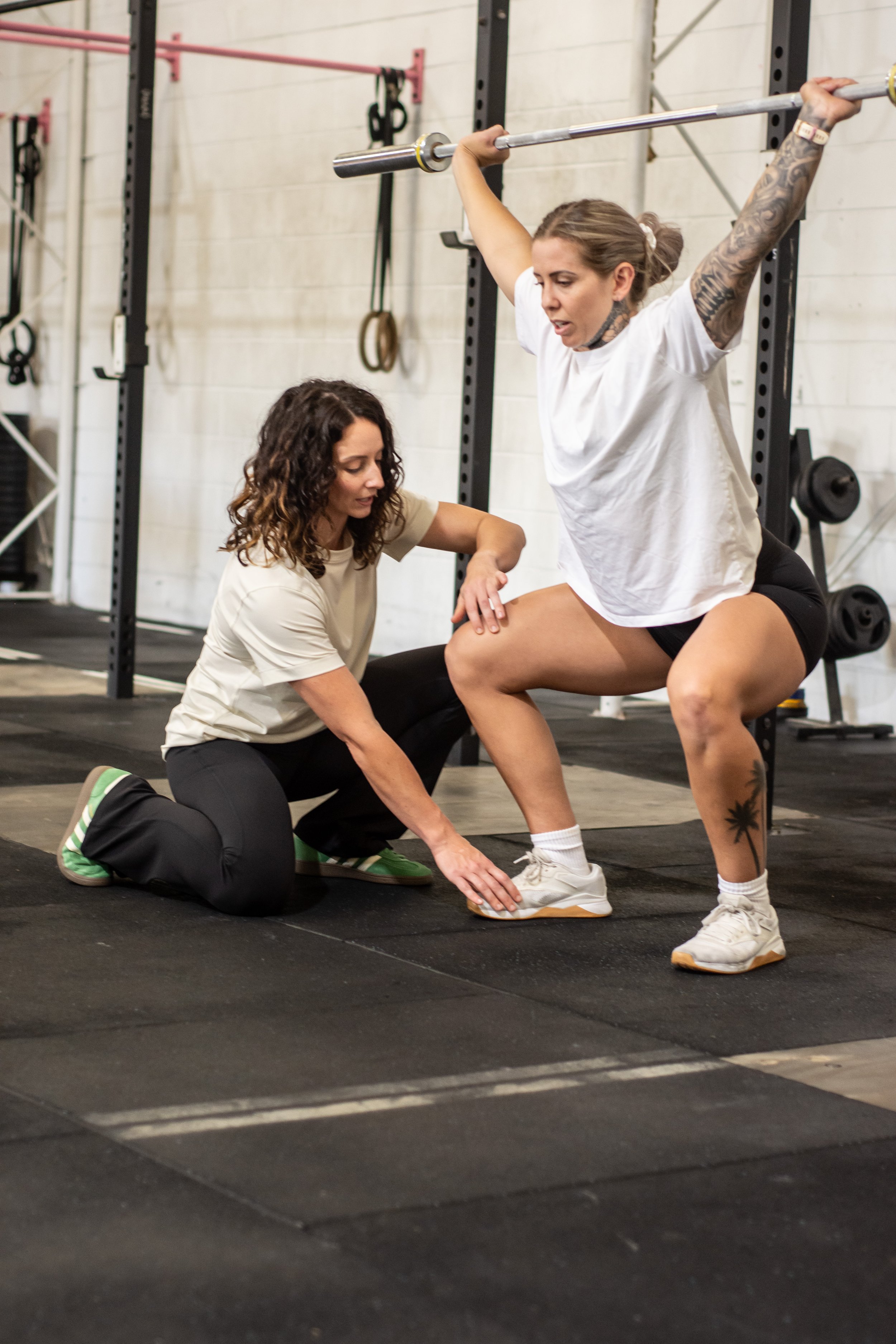 Physiotherapist guiding patient through barbell rehabilitation exercises