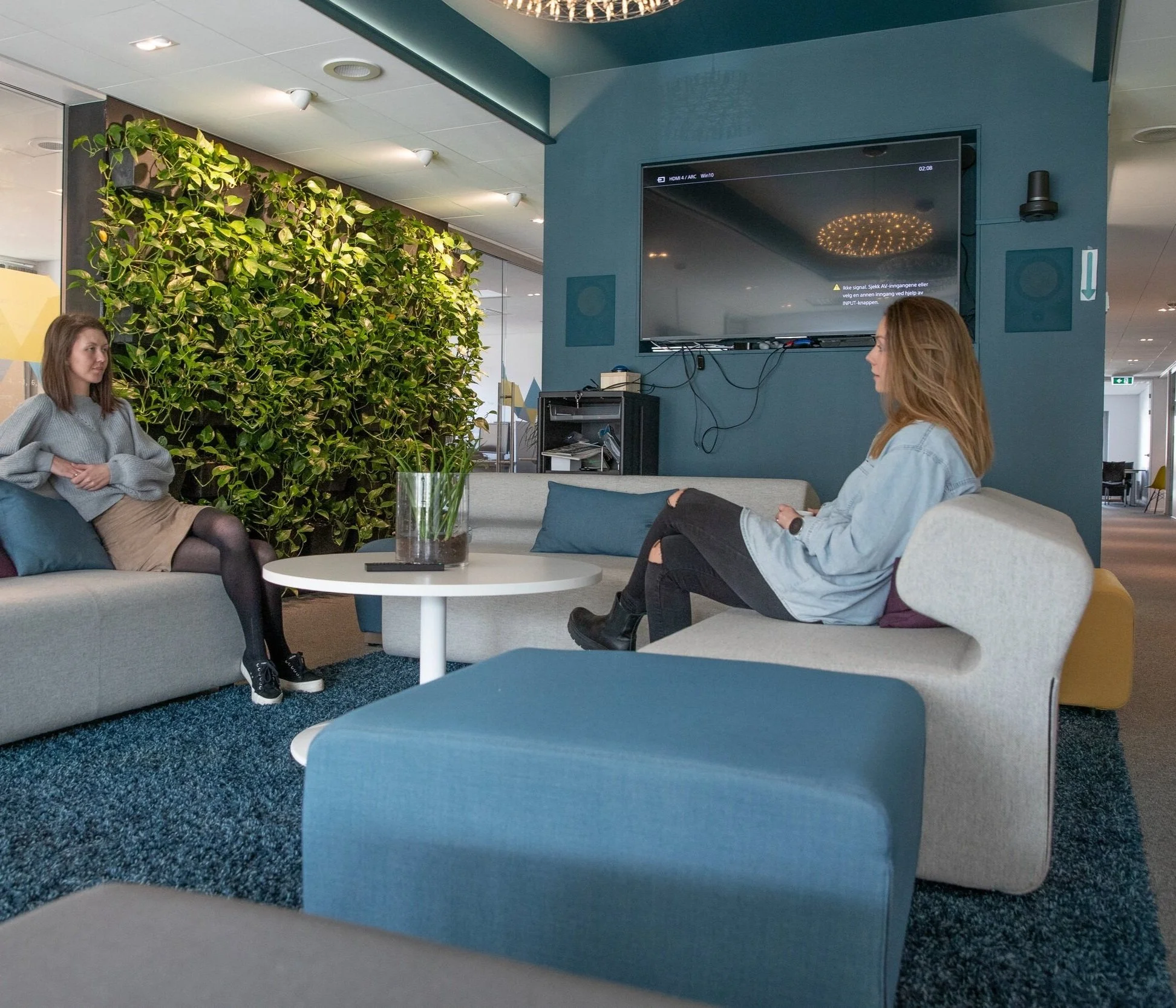 To damer i sofaen i sosial sone på kontor