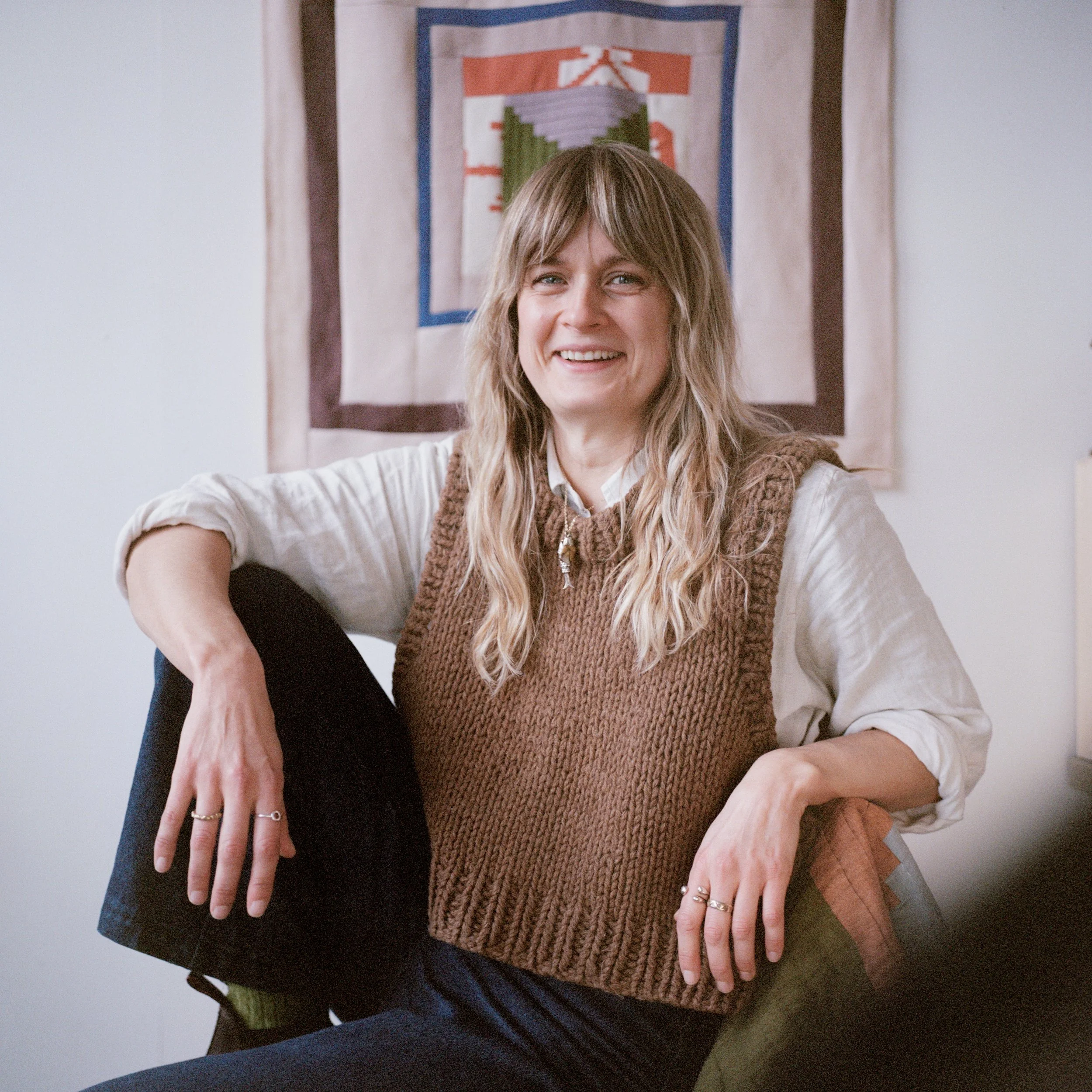 Photograph by cecile maia pujol - girl in brown knitted vest sitting down smiling