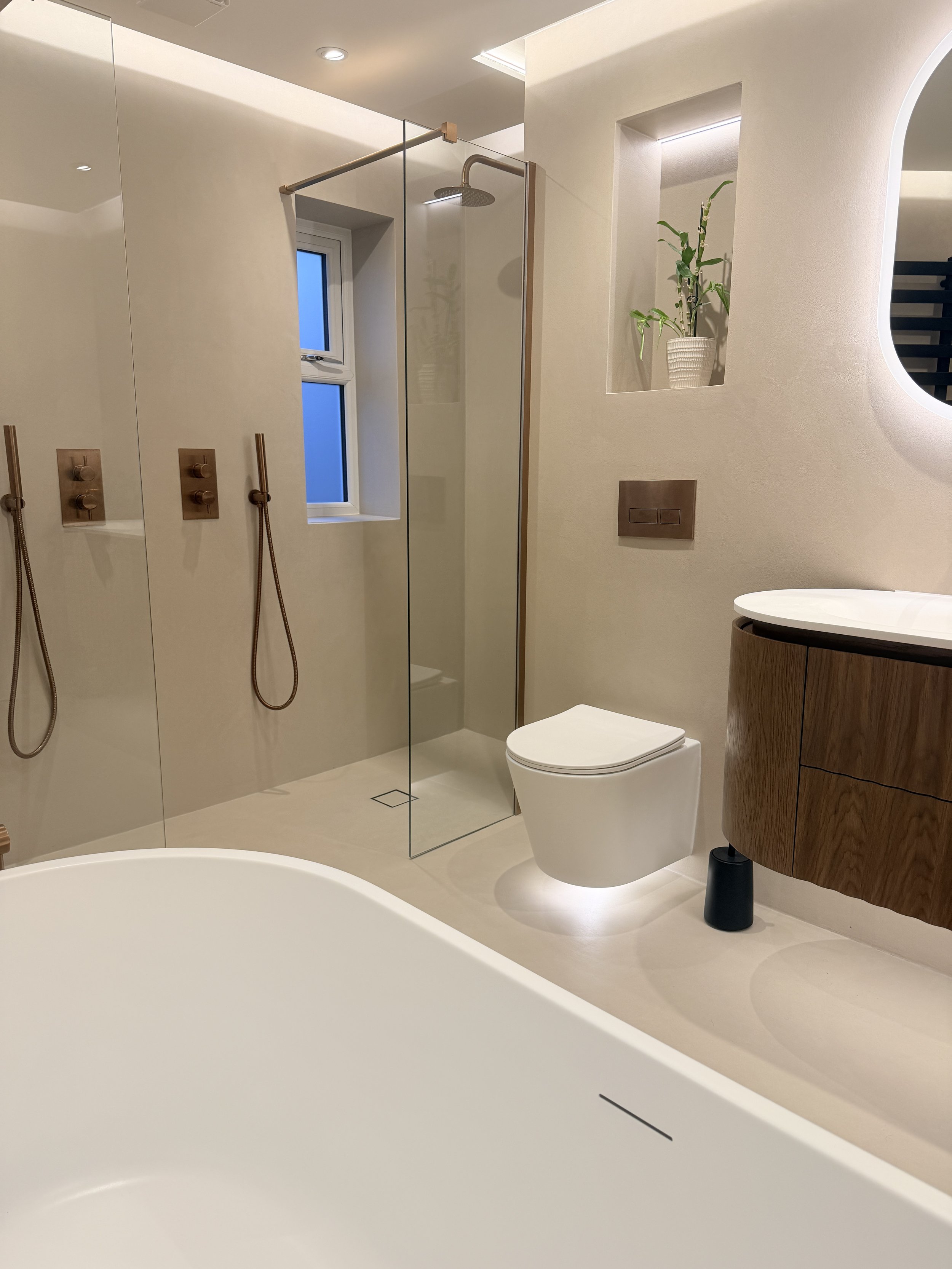 Beige walk in his and hers microcement shower and bathroom