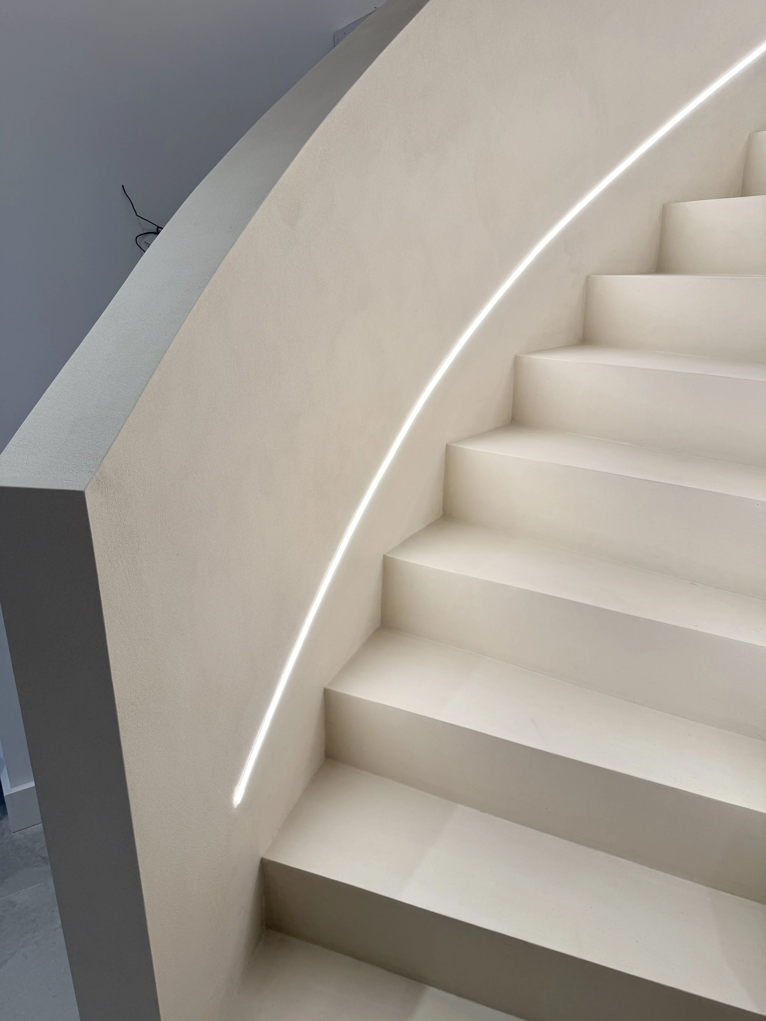 Microcement curved staircase in Liverpool with LED lighting