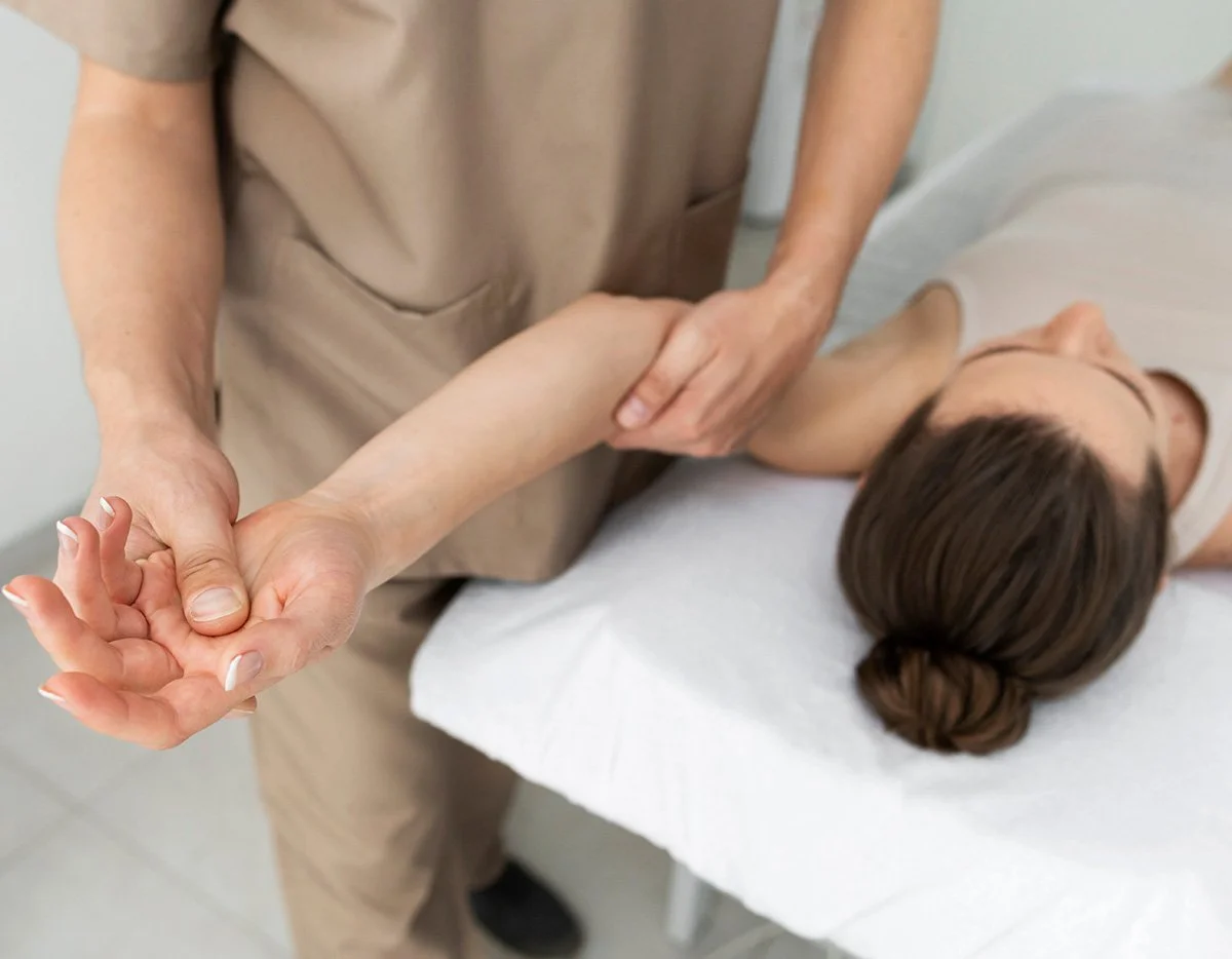 Professionnel effectuant un soin de kinésithérapie sur le poignet d'une patiente.