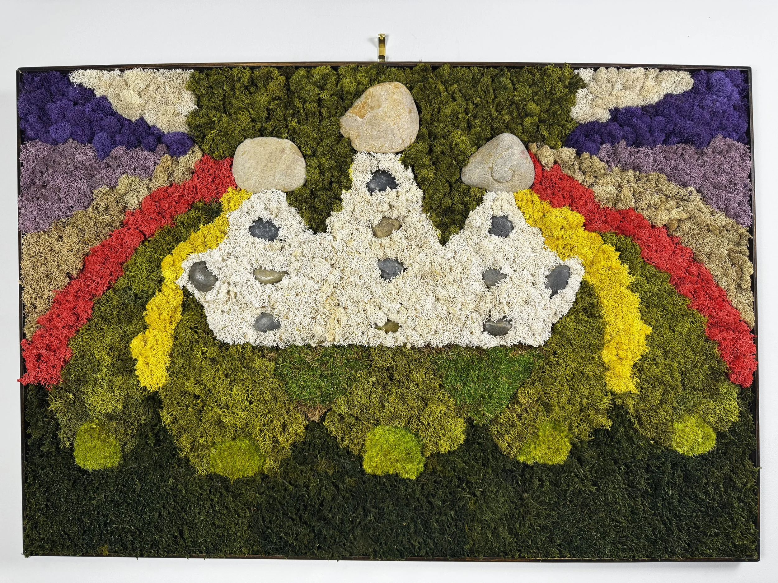 Title: Praise!
•	Date:  2026
•	Medium: Moss, river stones
•	Dimensions: 35” x 24”
•	Description: At the center is crown of pure white, topped with 3 stones to represent the Holy Trinity and adorned with 12 stones representing the 12 tribes of Israel.