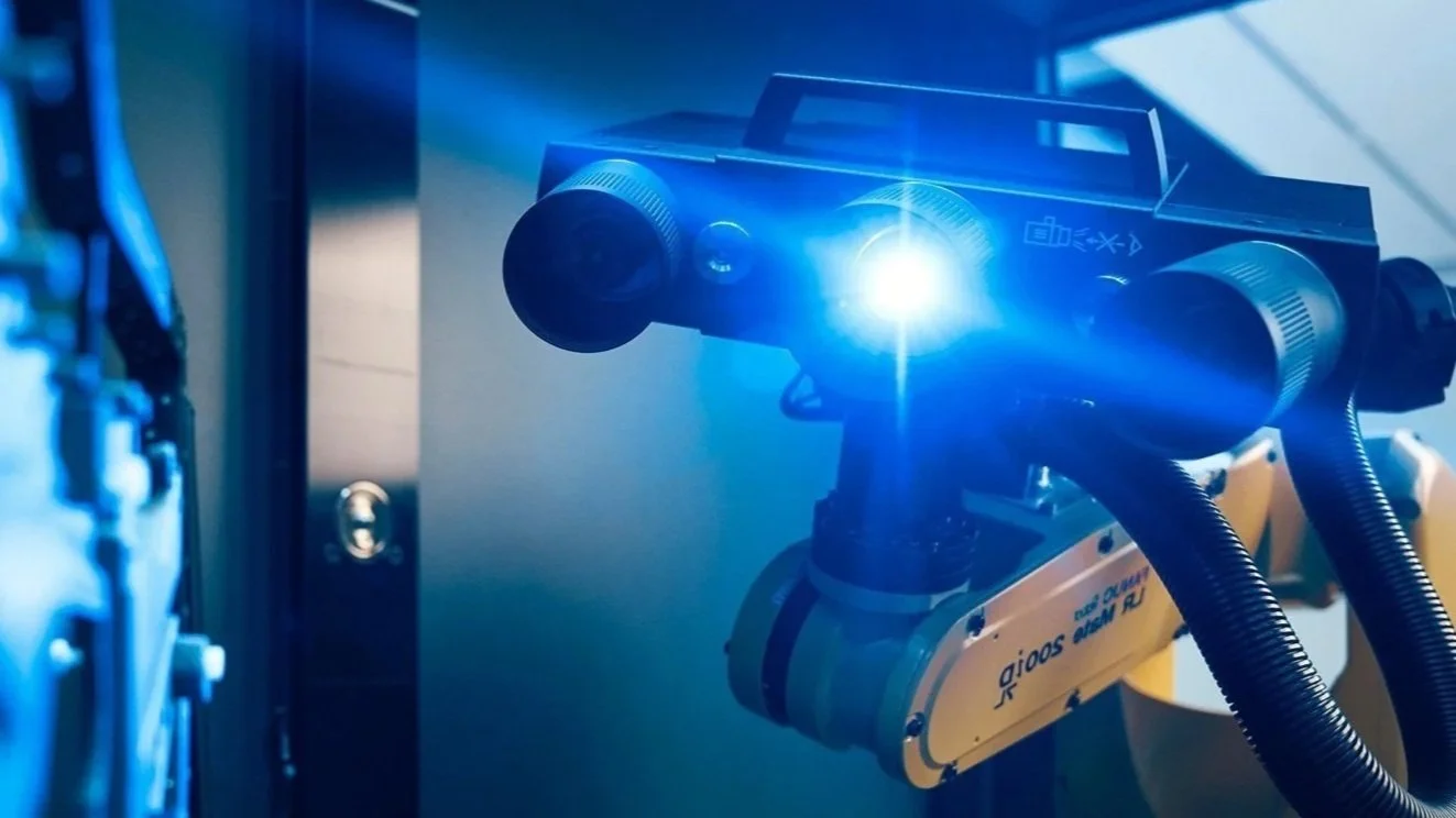 Robottikäsi ja laser tai valo, käytössä teollisessa tai tutkimusympäristössä.