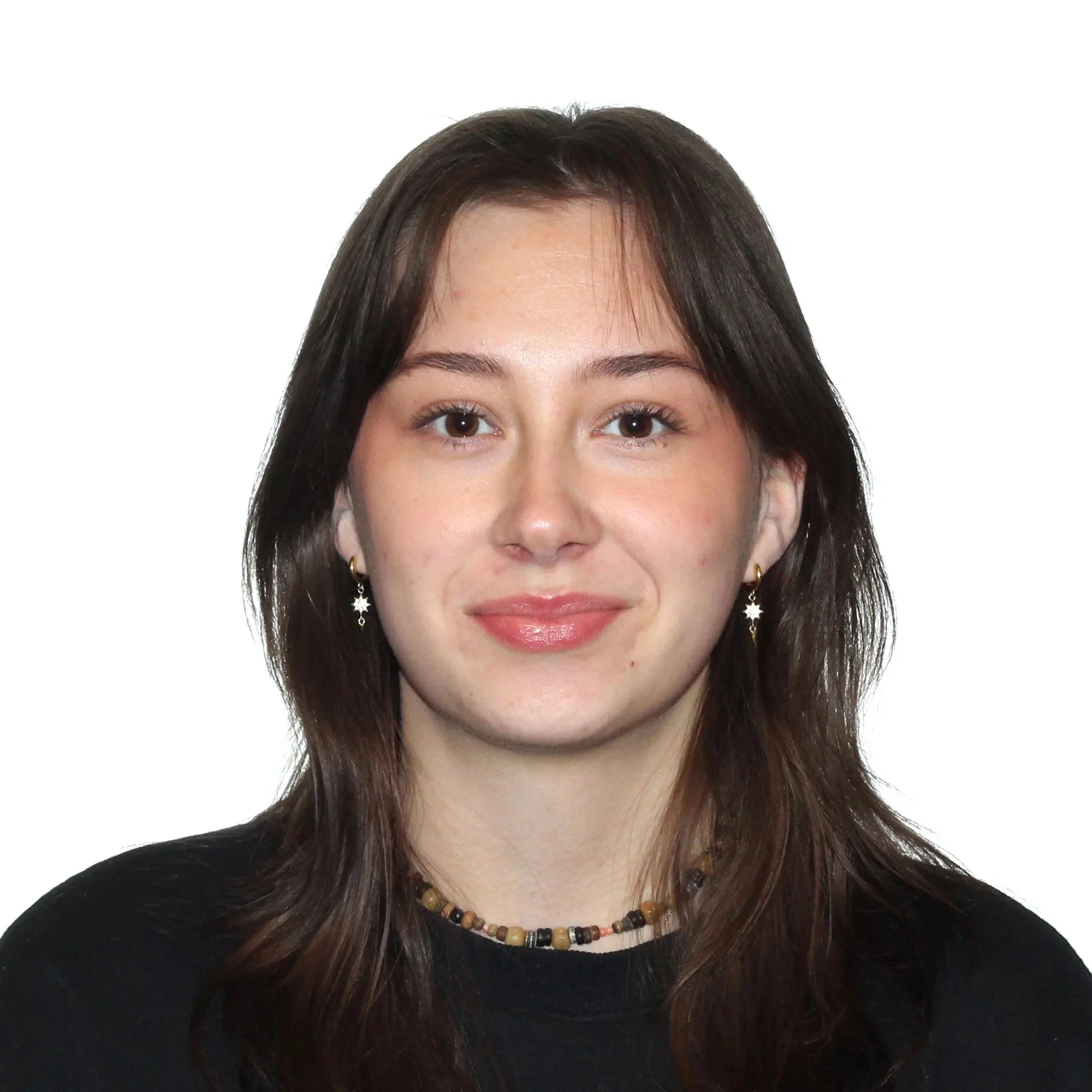 Nuori nainen, ruskeat hiukset, musta paita, koruja, neutraali ilme.