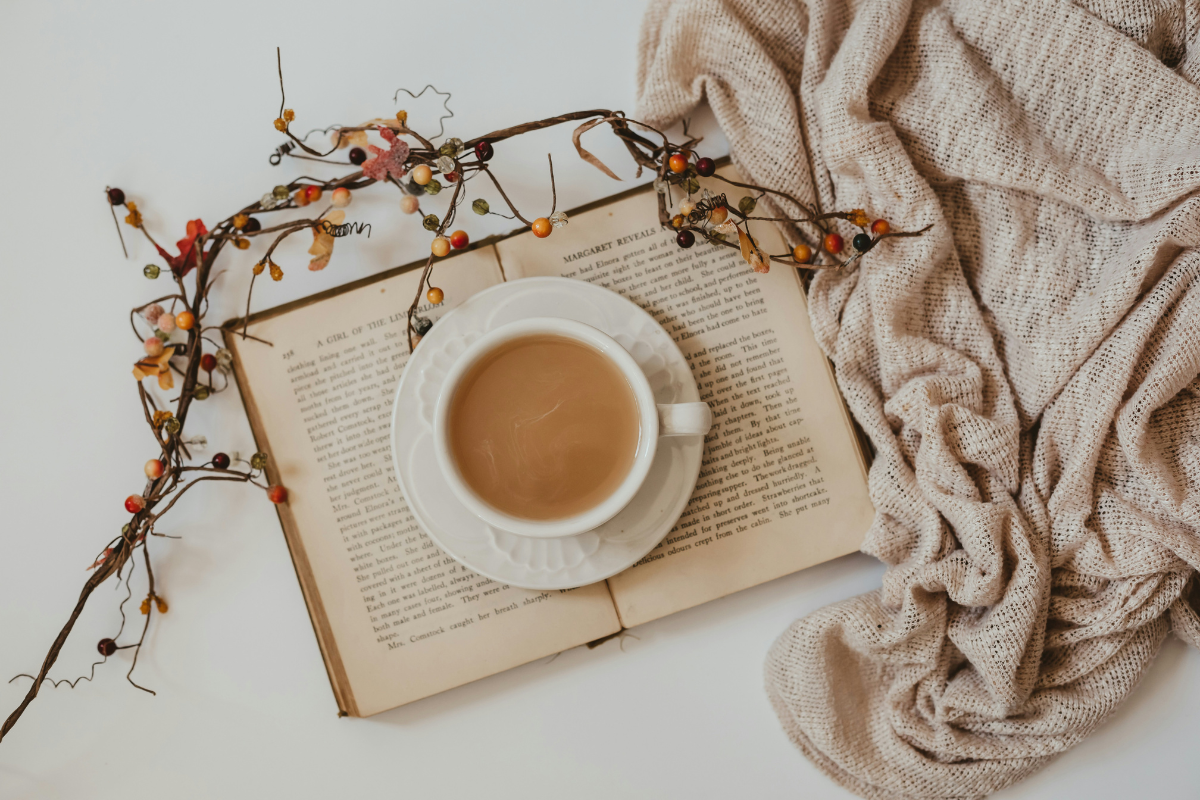 Book, beige blanket and a cup of tea