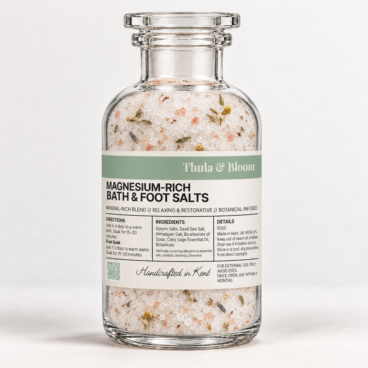 Glass jar of Thula & Bloom magnesium-rich bath and foot salts with white and pink mineral crystals and dried botanicals