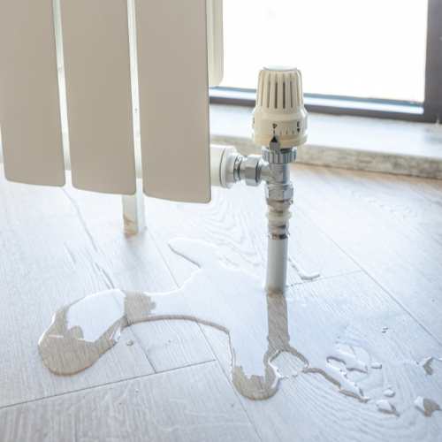 Hot water leaking from a radiator valve onto the floor. Norwich Plumbing and Heating Ltd.