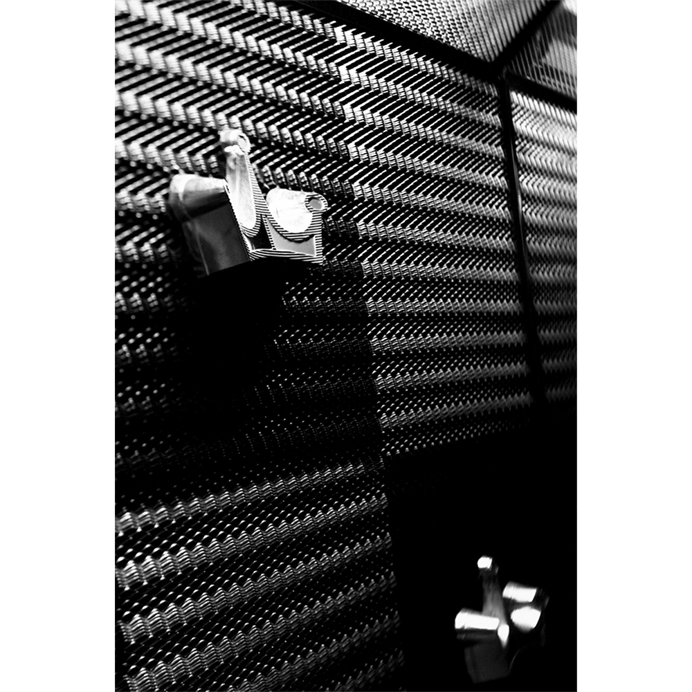 ilver gelatin photograph 'Seeburg' — close-up of a vintage jukebox's woven metal grille and chrome detail, hand-printed.