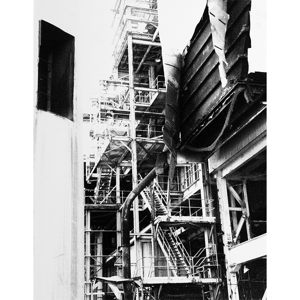Silver gelatin photograph 'In Progress' — industrial steel scaffolding, stairs, and ductwork against a bright sky, hand-printed.